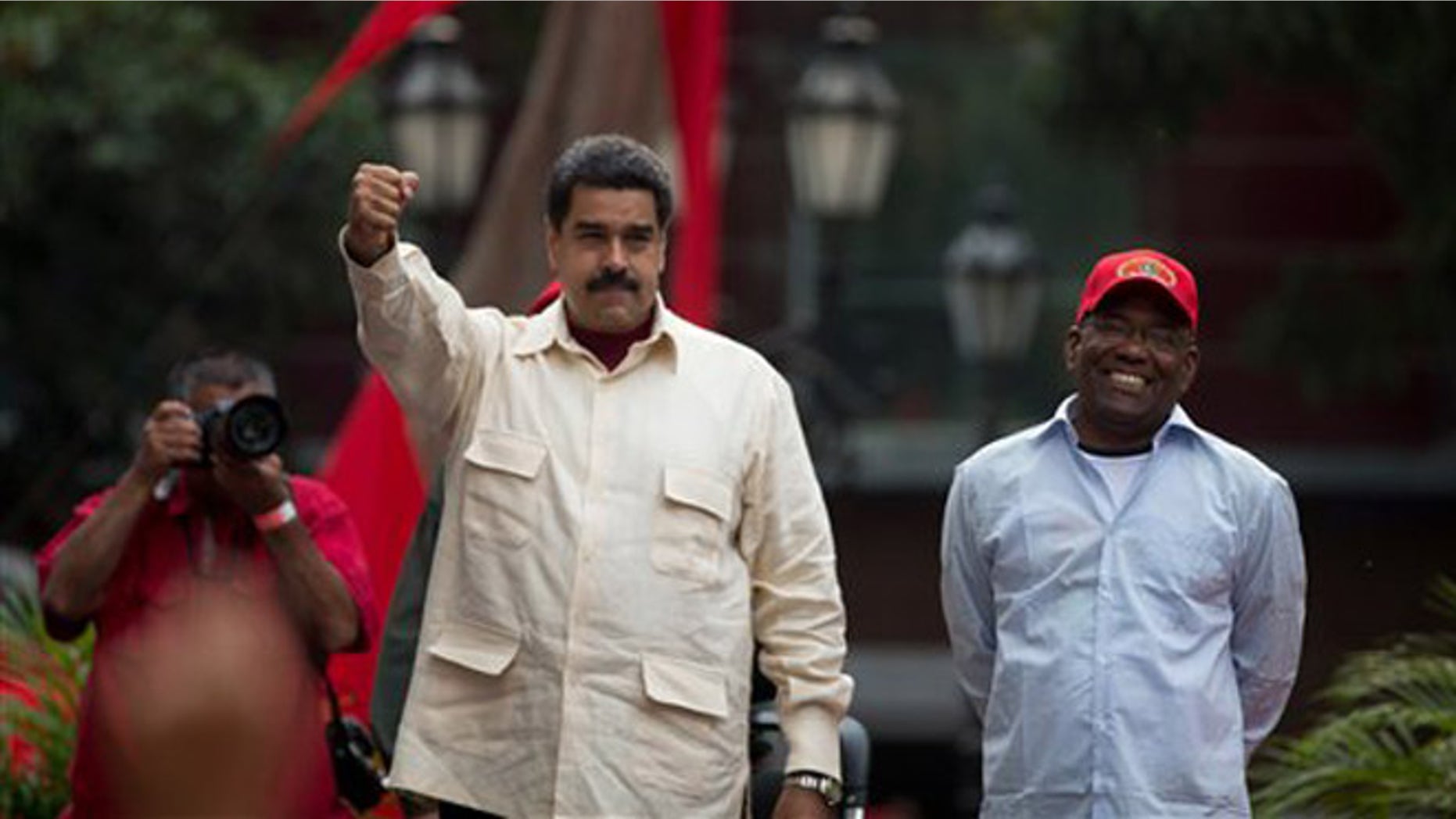 Venezuelas President Nicolas Maduro holds out his right fist while standing next to Vice President Aristobulo Isturiz during a ceremony marking the 206th anniversary of the call for independence from Spain, in Caracas, Venezuela, Tuesday, April 19, 2016. Opposition members are calling for Venezuelans to demonstrate across the country Tuesday to pressure Maduro to leave office. (AP Photo/Fernando Llano)