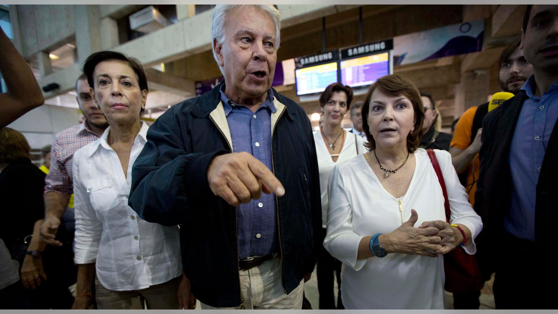 Spain's former president Felipe Gonzalez walks with Antonieta Mendoza, mother of jailed opposition leader Leopoldo Lopez, left, and Mitzy Capriles, wife of imprisoned Caracas Mayor Antoino Ledezma upon his arrival at Maiquetia International airport in la Guaira, Venezuela, Sunday, June 7, 2015.