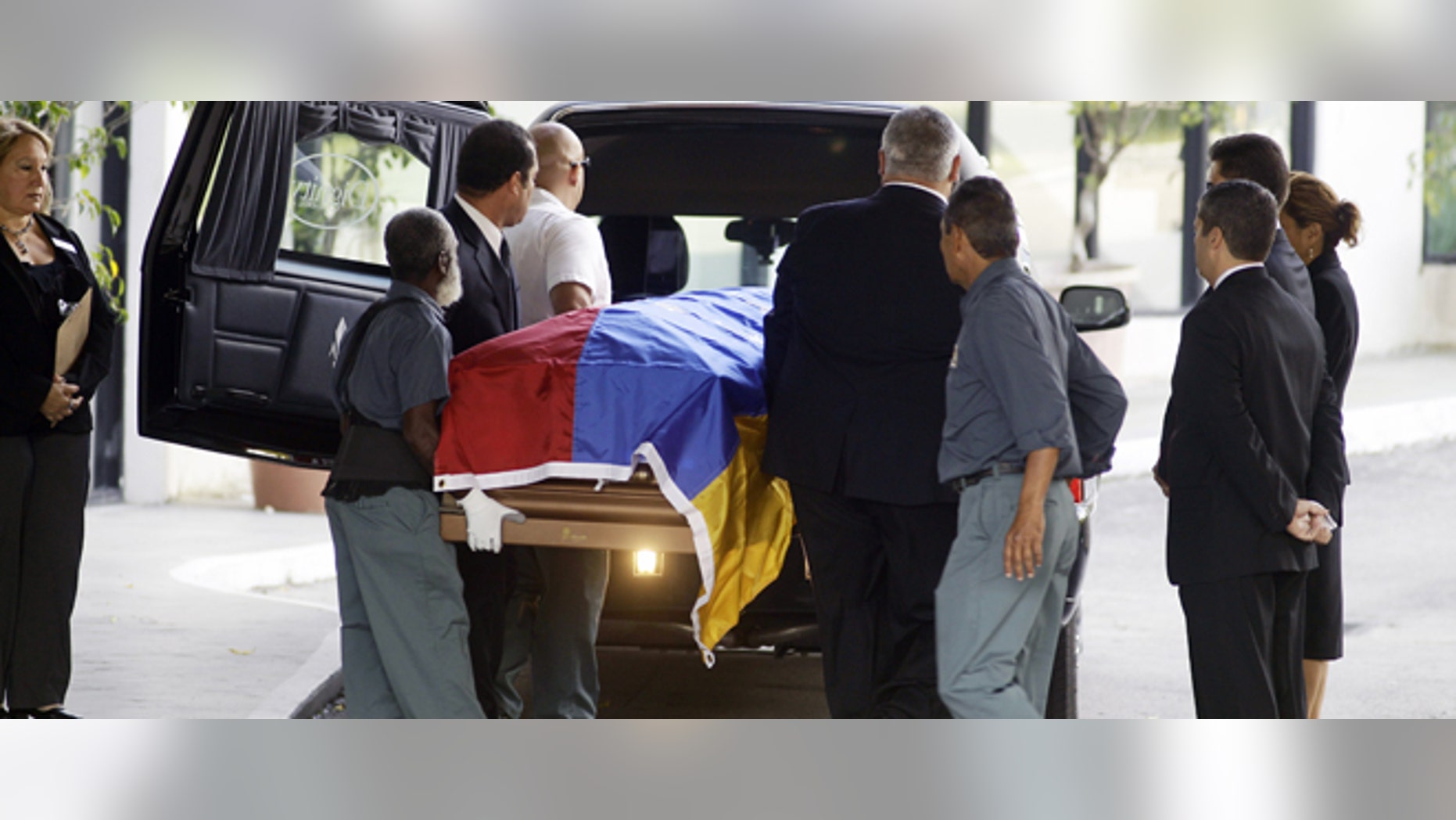 Workers carry the body of former Venezuelan President Carlos Andres Perez from the mausoleum to the hearse in Miami. Perez is finally going home, more than nine months after he died living in exile in Miami.