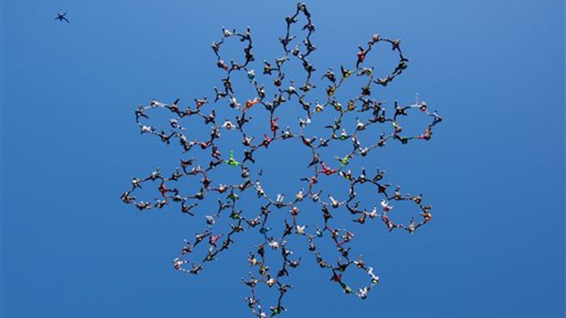 July 31: In this photo provided by Jason Peters, members of an international team of skydivers join hands flying head-down to build their world record skydiving formation over Ottawa, Ill.