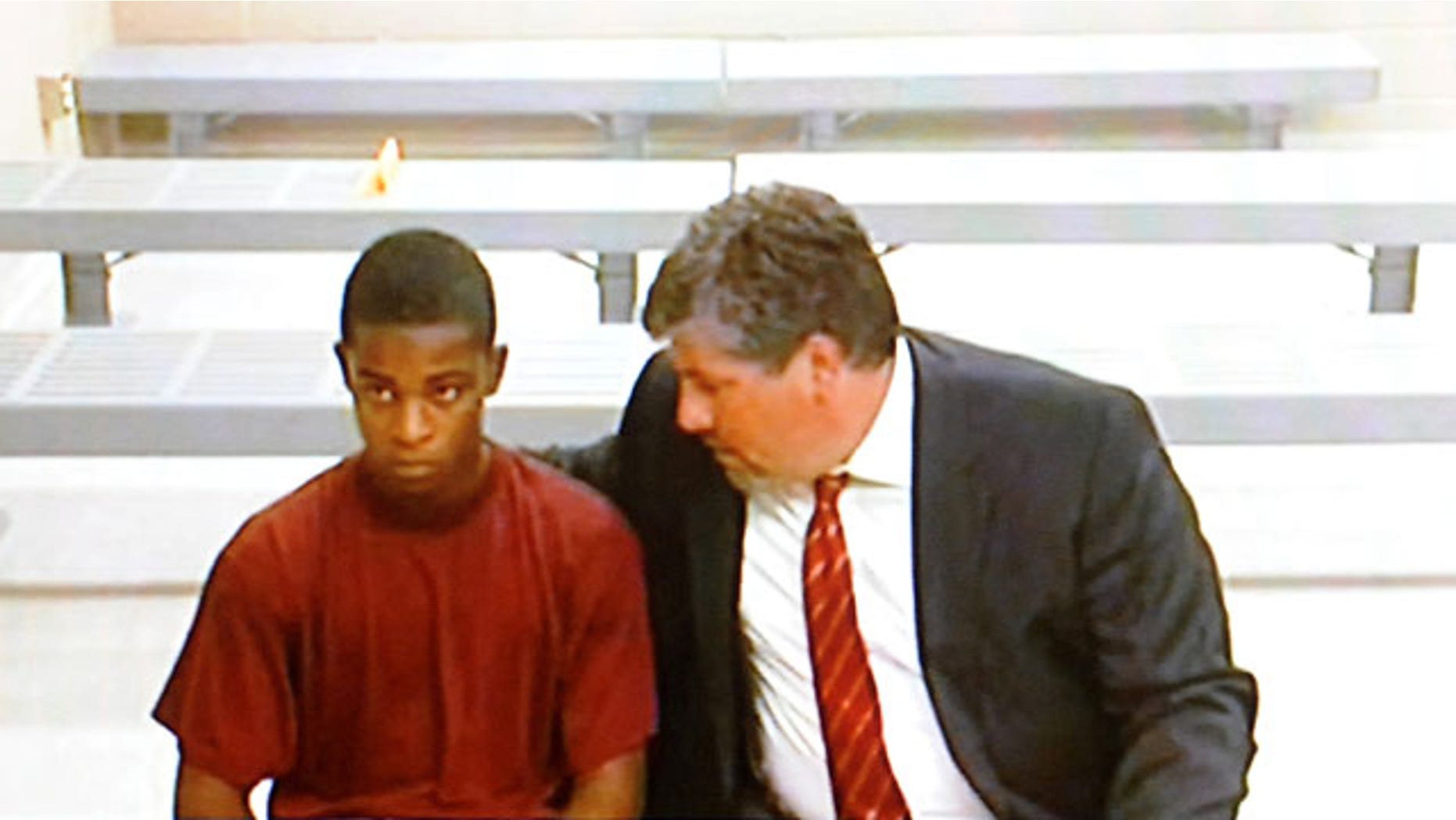 August 26, 2013: Demetrius Glenn, left, a teen that allegedly took part in the robbery and beating of 88-year-old World War II veteran Delbert Belton, listens to his lawyer, Christian J. Phelps, before a first appearance via video teleconference in District Court in Spokane, Wash. Glenn, who will be charged as an adult, is charged with first-degree murder and first-degree robbery and was ordered held on $2 million bail. (AP Photo/The Spokesman-Review)