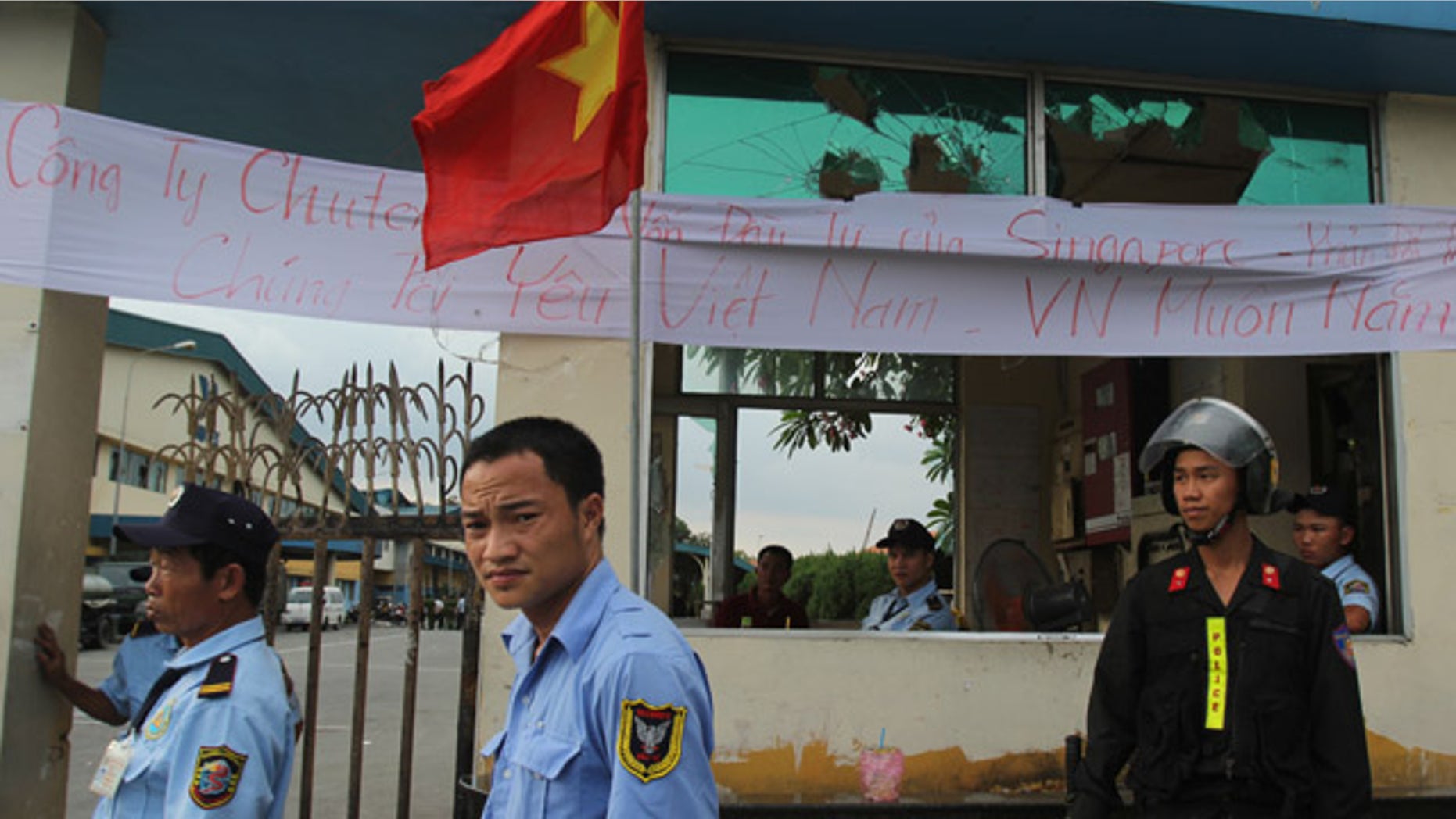 May 17, 2014: Security staff guard the entrance to a Singaporean factory in an industrial park in Binh Duong province, Vietnam after mobs attacked foreign owned factories following anti-China protests. (AP Photo/Hau Dinh)