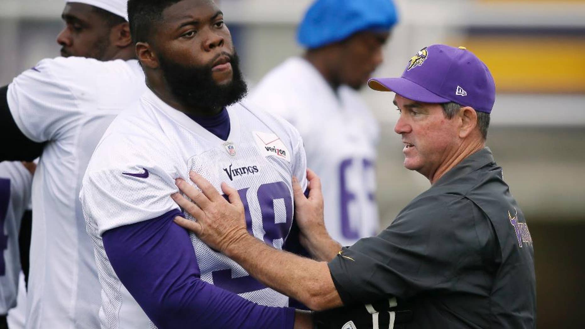 Minnesota Vikings head coach Mike Zimmer instructs defensive tackle Linval Joseph during an NFL football training camp, Saturday, July 26, 2014, in Mankato, Minn. (AP Photo/Charlie Neibergall)