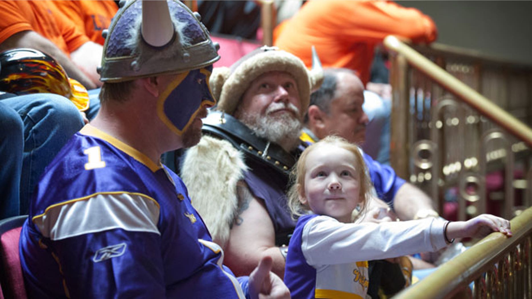 May 8, 2012: Minnesota Vikings fan Hannah Walsh, 5, sits between "Skolt," left, also known as Scott Asplund, and Greg Hanson, who goes by Sir Odin, as the state Senate discussed the Vikings stadium bill in St. Paul, Minn.