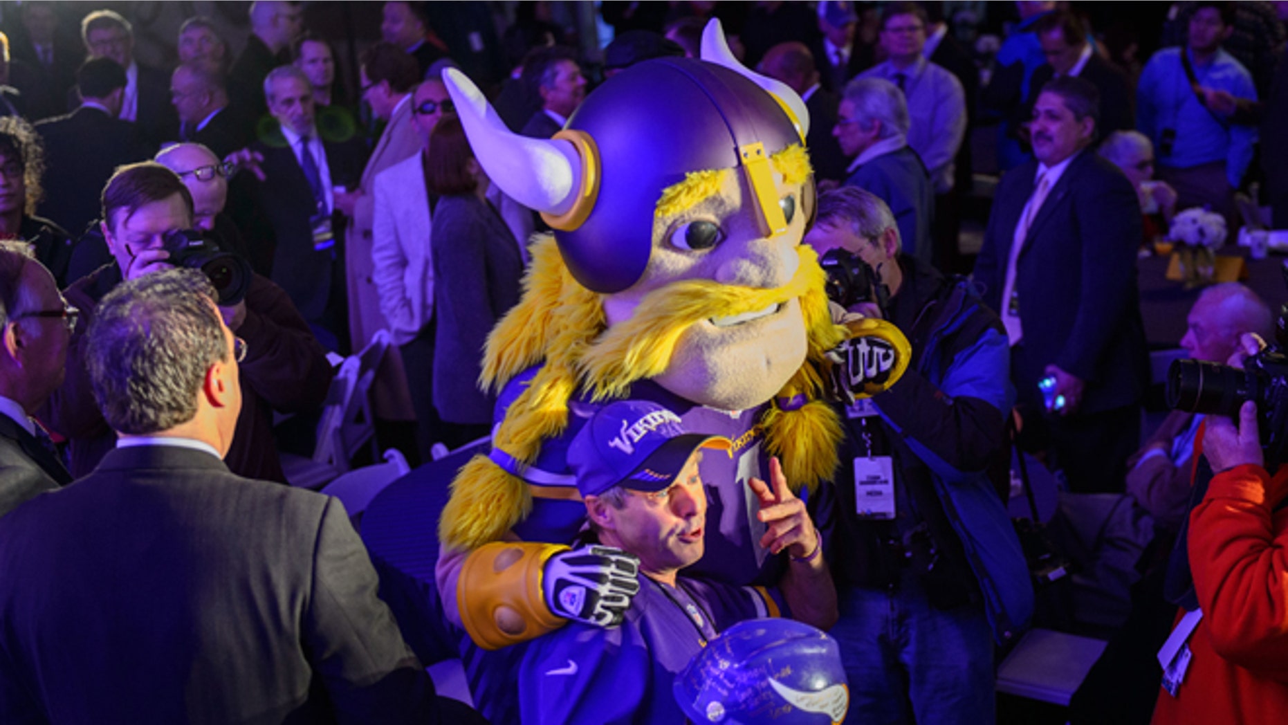FILE: Dec. 3, 2013: A Minnesota Vikings fan with the team mascot during the groundbreaking ceremony for the new Vikings stadium, in Minneapolis, Minn.