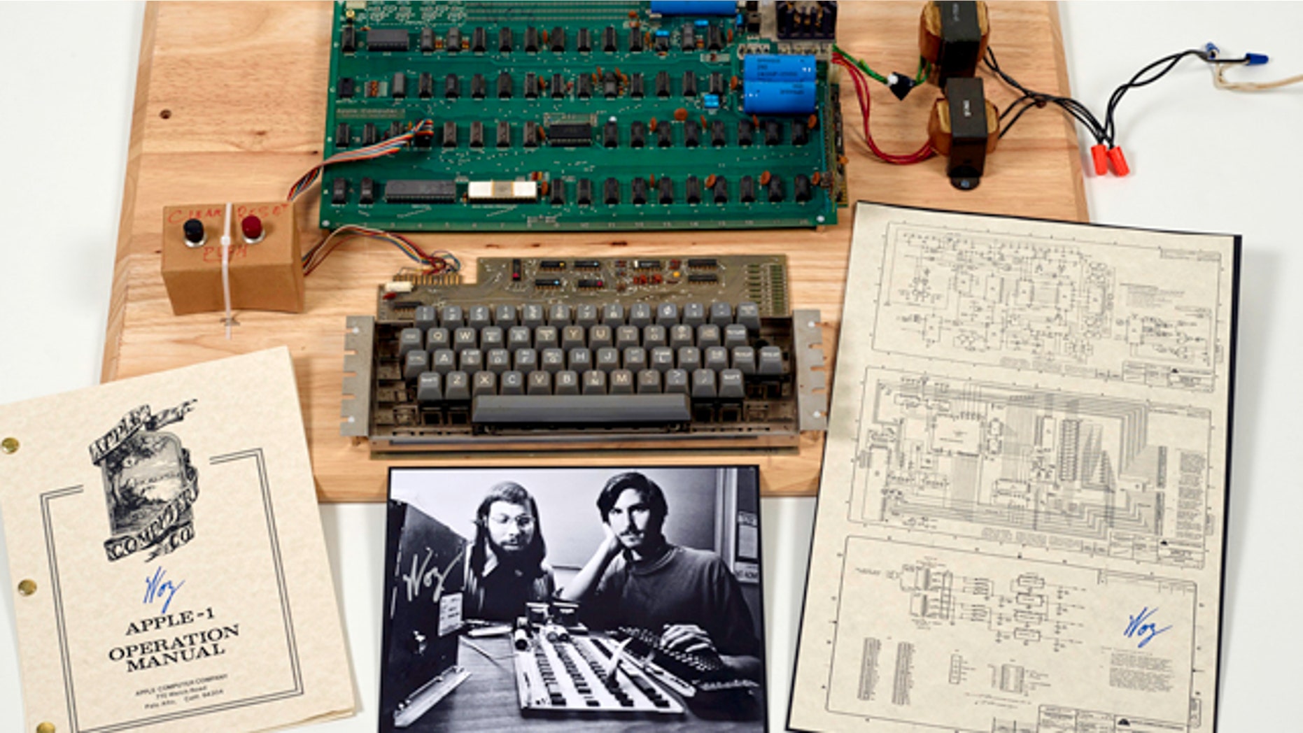 This undated photo provided by Christie’s Auction House shows an “Apple 1” prototype computer, built in 1976, accompanied by an operation manual and schematic as well as a photo of its inventors, Steve Wozniak, left, and Steve Jobs.
