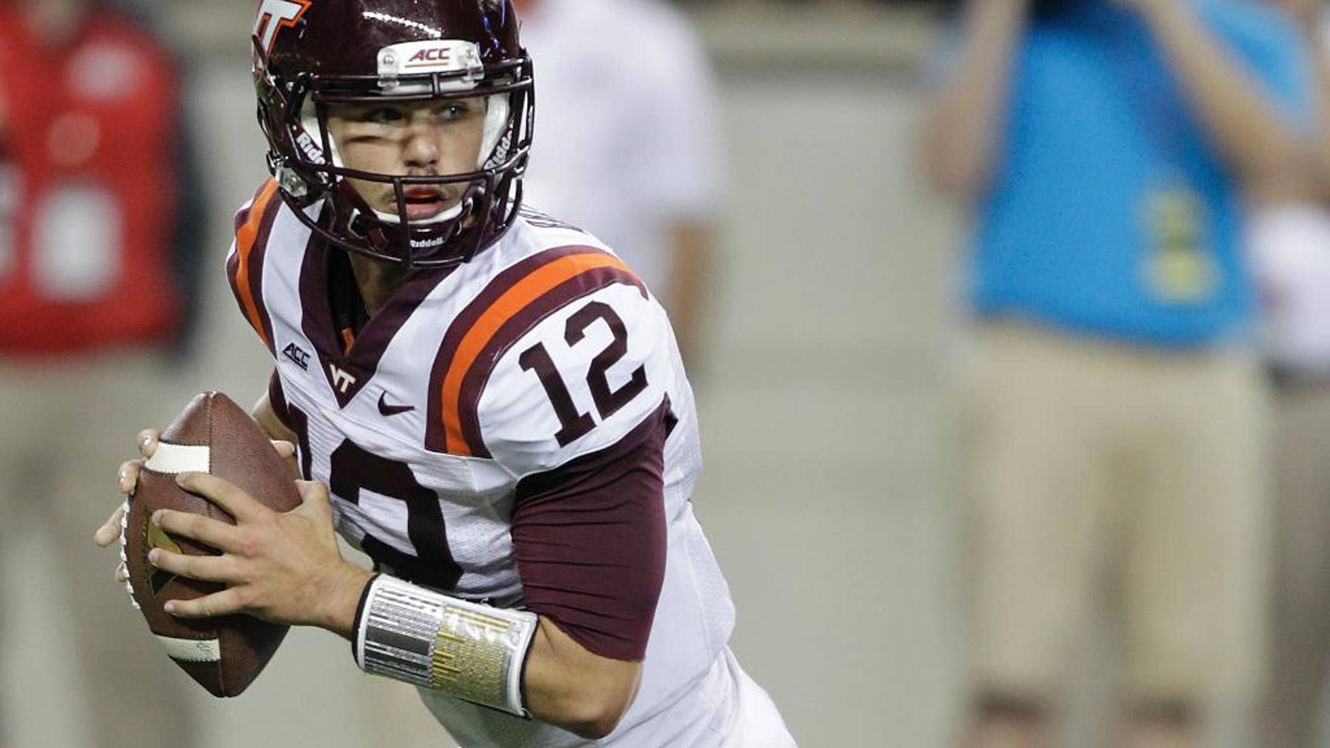 FILE- In this Sept. 6, 2014, file photo, Virginia Tech quarterback Michael Brewer rolls out against Ohio State during an NCAA college football game in Columbus, Ohio. Virginia Tech's loss to East Carolina made the high of winning the previous week at Ohio State a distant memory, Brewer said, and brought back into focus the Hokies' goal of playing well when they begin Atlantic Coast Conference play on Saturday against Georgia Tech. (AP Photo/Jay LaPrete, File)