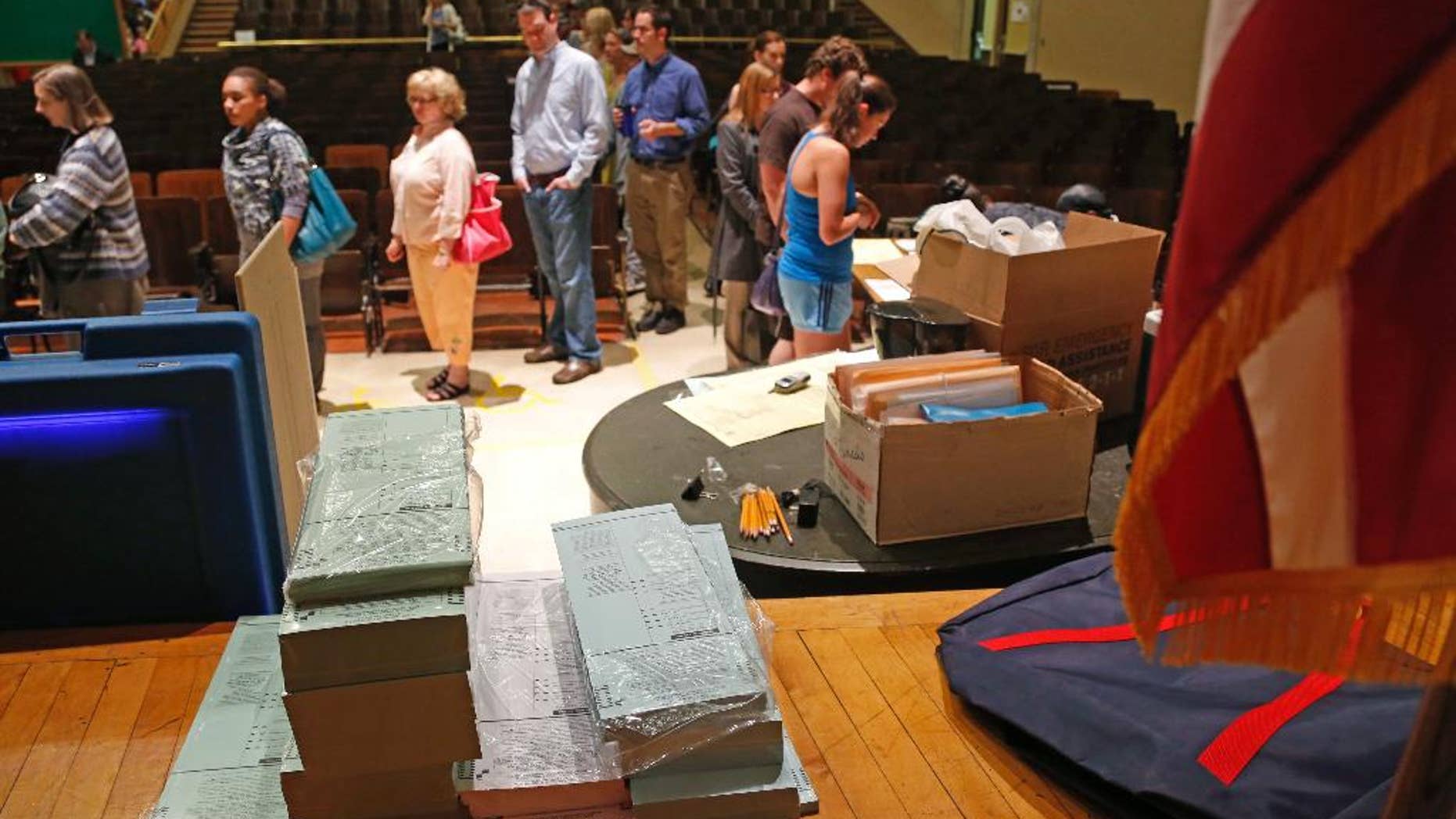 FILE - In this June 5, 2012 file photo, voting ballots are stacked and ready as voters wait in line to cast their ballot in Milwaukee. A federal appeals panel was set to hear arguments Friday, Sept. 12, 2014 on whether an embattled Wisconsin law requiring voters to show photo identification at the polls should be reactivated in time for the November elections following a nearly three-year legal battle. Attorneys representing the state Justice Department were expected to defend the law in front of a three-judge panel of the 7th Circuit Court of Appeals in Chicago. (AP Photo/Jeffrey Phelps, File)