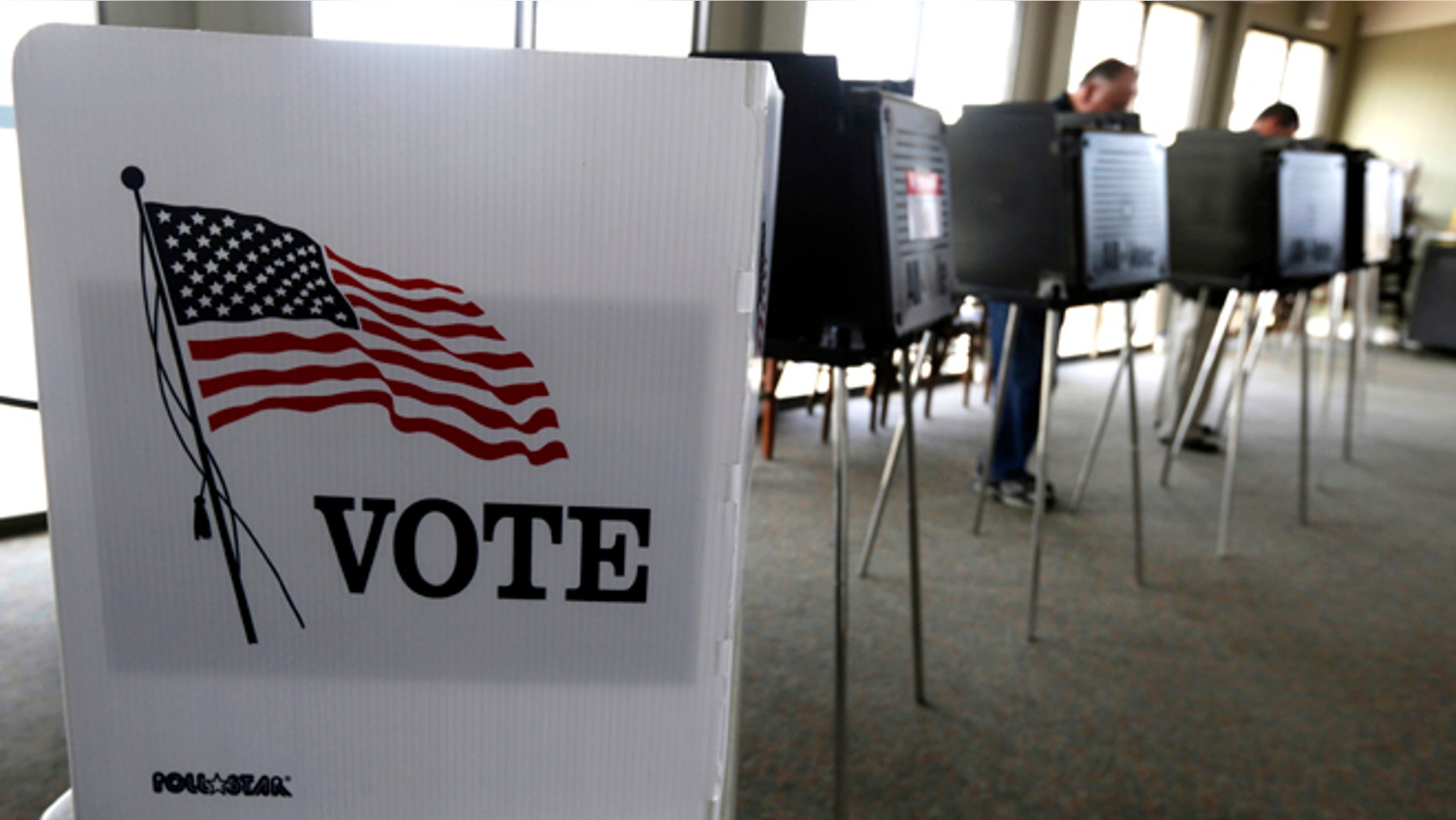 FILE - In this March 18, 2014 file photo, voters cast their ballots in the Illinois primary in Hinsdale, Ill. Republicans have gained ground on Democrats' strength in registering voters in three battleground states _ and kept their razor-thin advantage in Iowa, offering some hope for Donald Trump and raising the stakes over ballot access in the final weeks before Election Day. (AP Photo/M. Spencer Green, File)