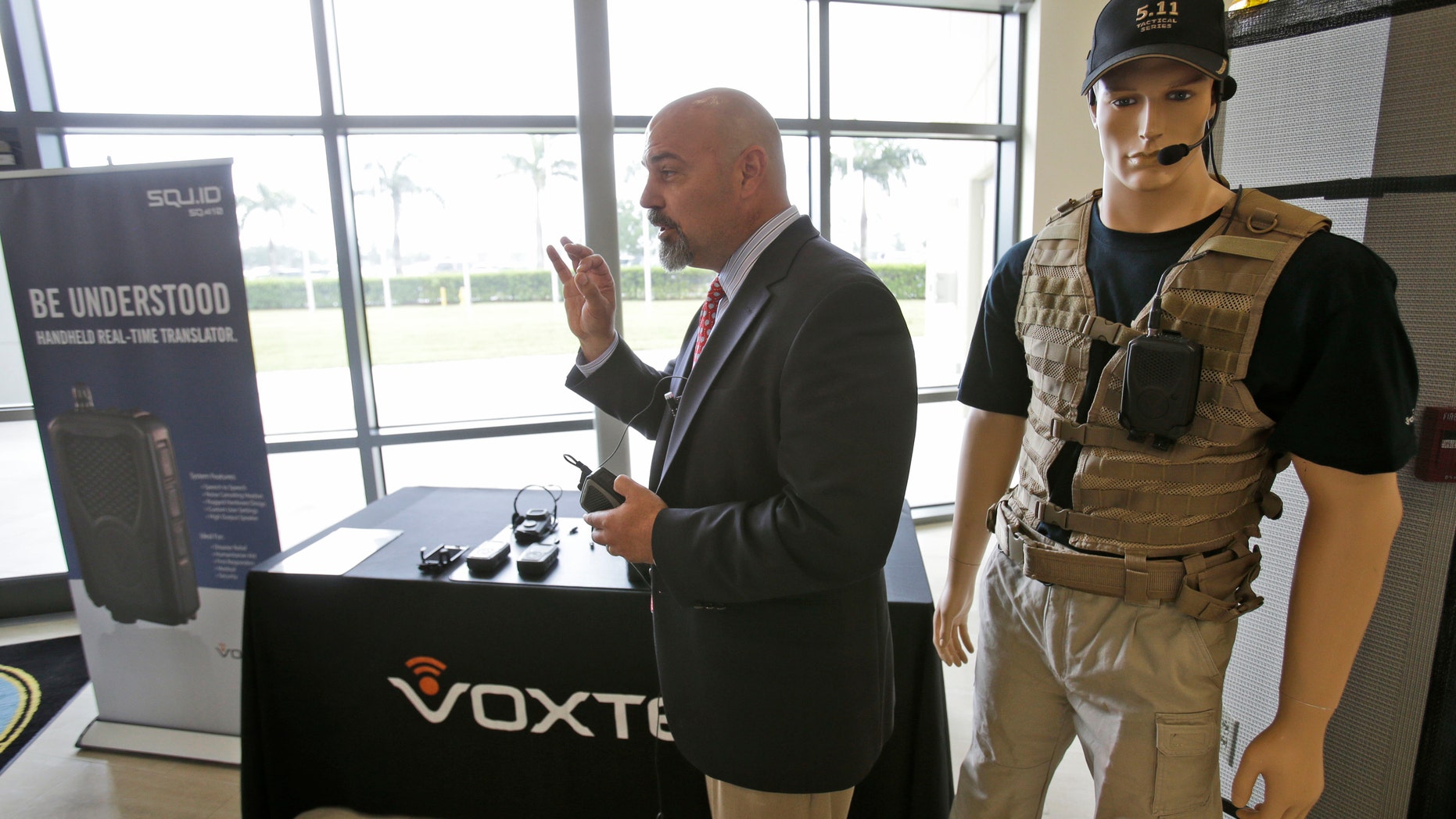 John Hall, president and CEO of Voxtec International, demonstrates his company's real-time translation system, during a media opportunity at the U.S. Southern Command headquarters.