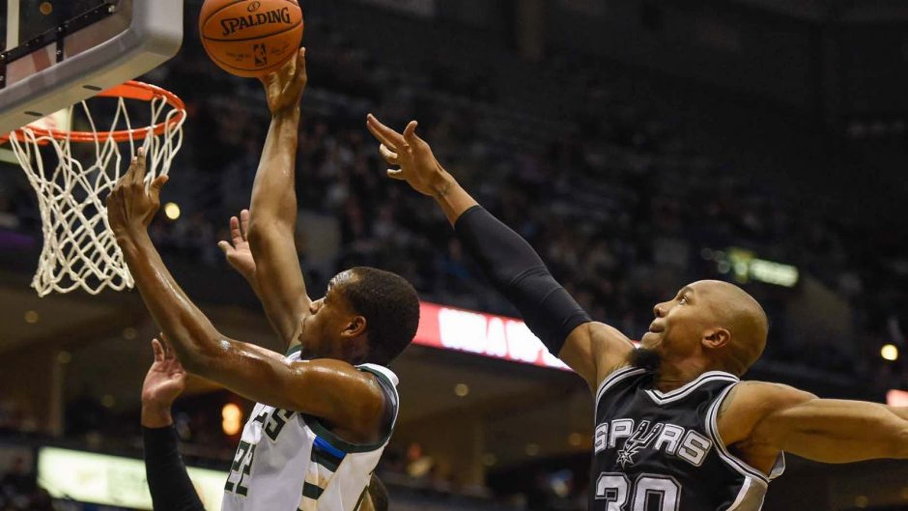 Monday, Jan. 4: Milwaukee Bucks guard Khris Middleton (left) takes a shot against San Antonio Spurs forward David West in the first quarter at BMO Harris Bradley Center in Milwaukee, Wis.