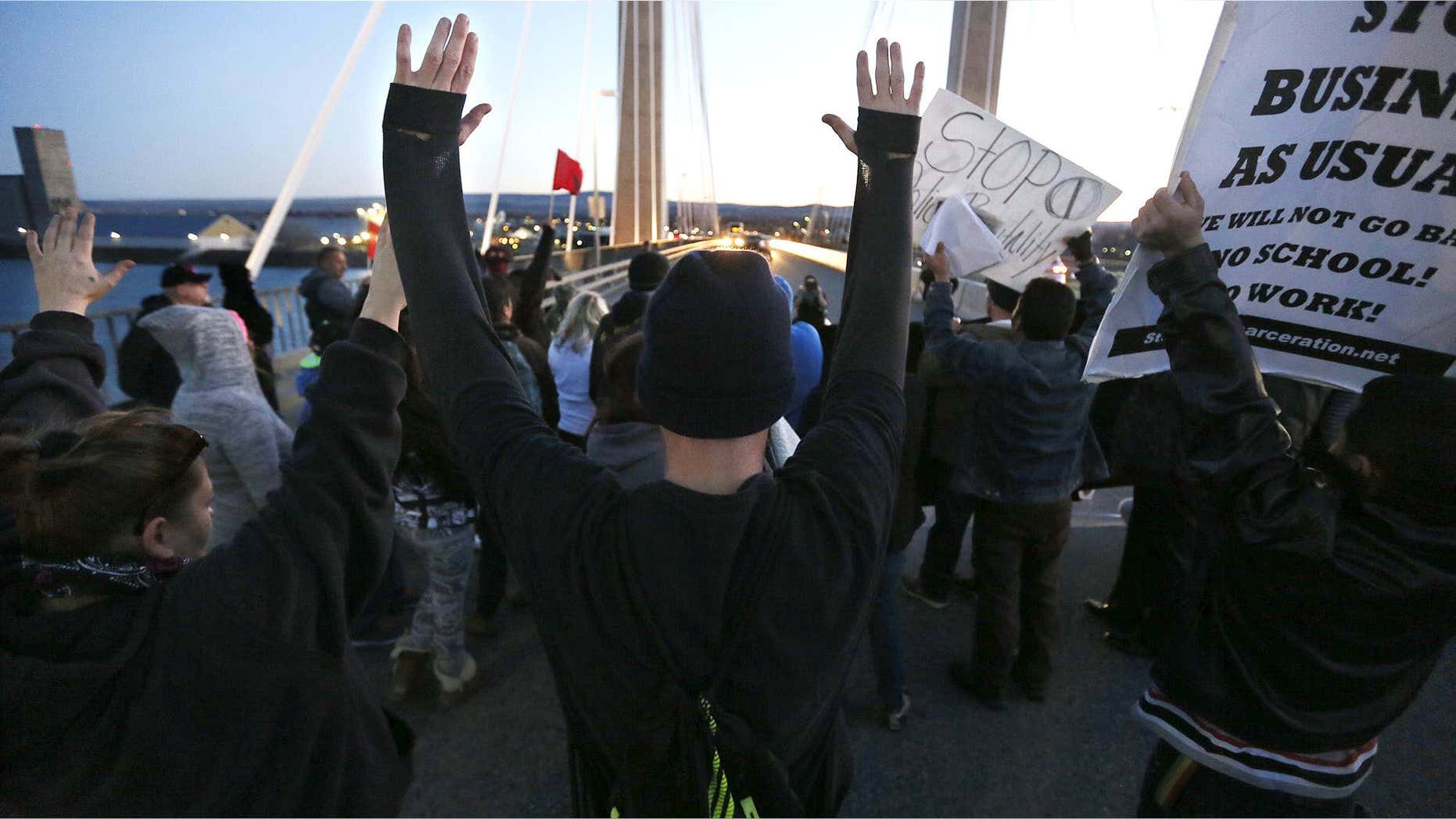 Feb. 21, 2015: Protesters hold up their hands and signs on the cable bridge.