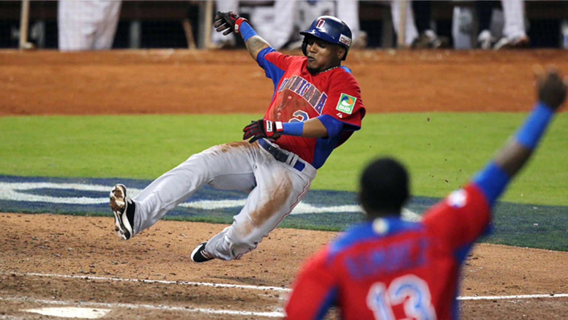 Dominican Republic's Erick Aybar slides safely into home on an RBI single by Jose Reyes against the United States during the ninth inning of their second-round game in the World Baseball Classic in Miami, Thursday, March 14, 2013. The Dominican Republic won 3-1. (AP Photo/El Nuevo Herald, David Santiago) MAGS OUT