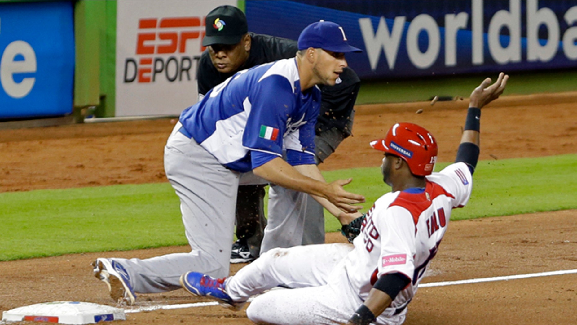 Puerto Rico's Irving Falu slides safely into third on a base hit by teammate Yadier Molina as Italy third baseman Alex Liddi awaits the late throw during the fourth inning of a second-round elimination game of the World Baseball Classic in Miami, Wednesday, March 13, 2013. Third base umpire Edgar Estivison watches the play. (AP Photo/Wilfredo Lee)