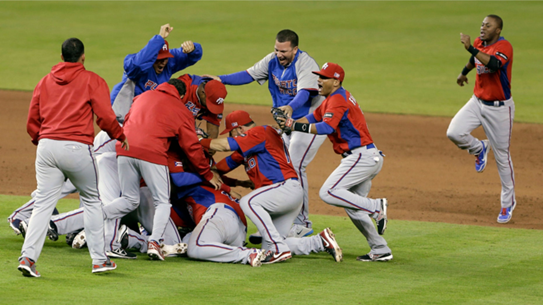 Puerto Rico players celebrate after defeating the United States 4-3 during a second-round elimination game of the World Baseball Classic, Friday, March 15, 2013, in Miami. (AP Photo/Wilfredo Lee)