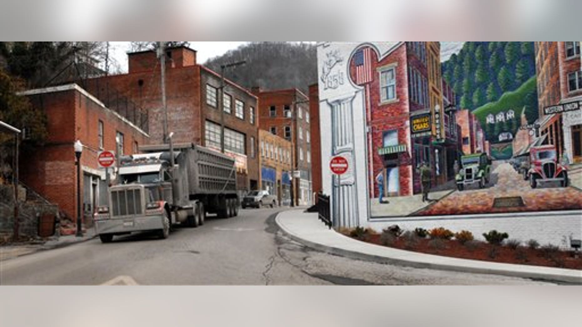 A coal truck drives out of downtown Welch, W.Va., Wednesday, Feb. 9, 2011. Coal brought a large population to the McDowell County in the 1940's. Now the population is shrinking and the county suffers from unemployment and poverty. Now, here as in one-fourth of all U.S. counties, West Virginia's graying residents are slowly dying off. Hit by an aging population and a poor economy, a near-record level of U.S. counties is experiencing more deaths than births in their communities, a phenomenon demographers call "natural decrease." (AP Photo/Jon C. Hancock)