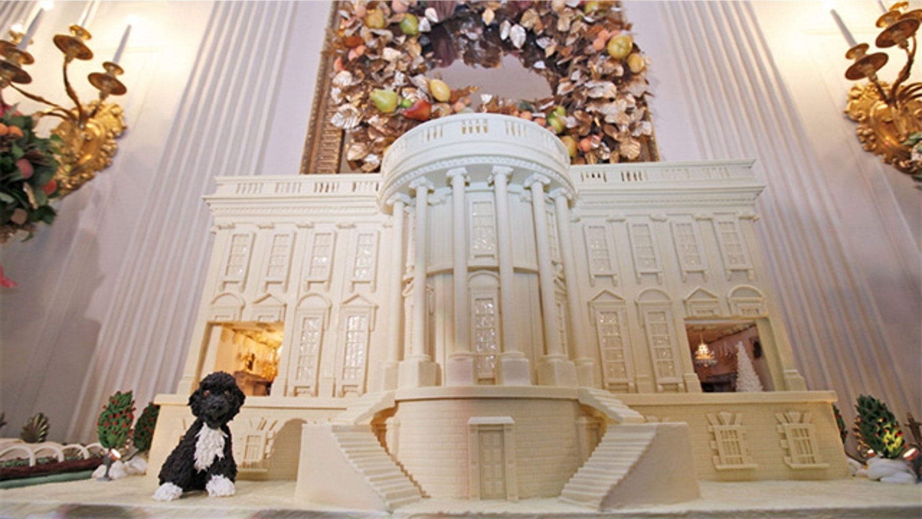 Dec. 1., 2011: A miniature of the Obama family's dog, Bo, sits on a 400-pound white chocolate-covered gingerbread replica of the White House in the State Dining Room of the White House in Washington, DC.