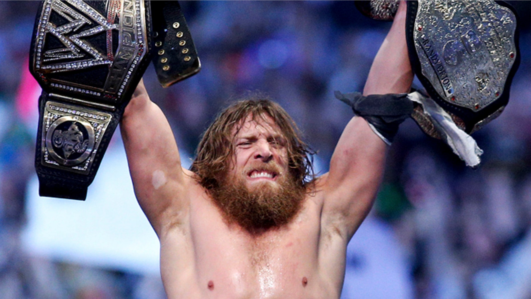 April 2014: Daniel Bryan celebrating after winning the main event during Wrestlemania XXX at the Mercedes-Benz Super Dome in New Orleans. Police say the former WWE champion, Bryan chased two burglary suspects he saw exiting his Phoenix home this week and subdued one until officers arrived.