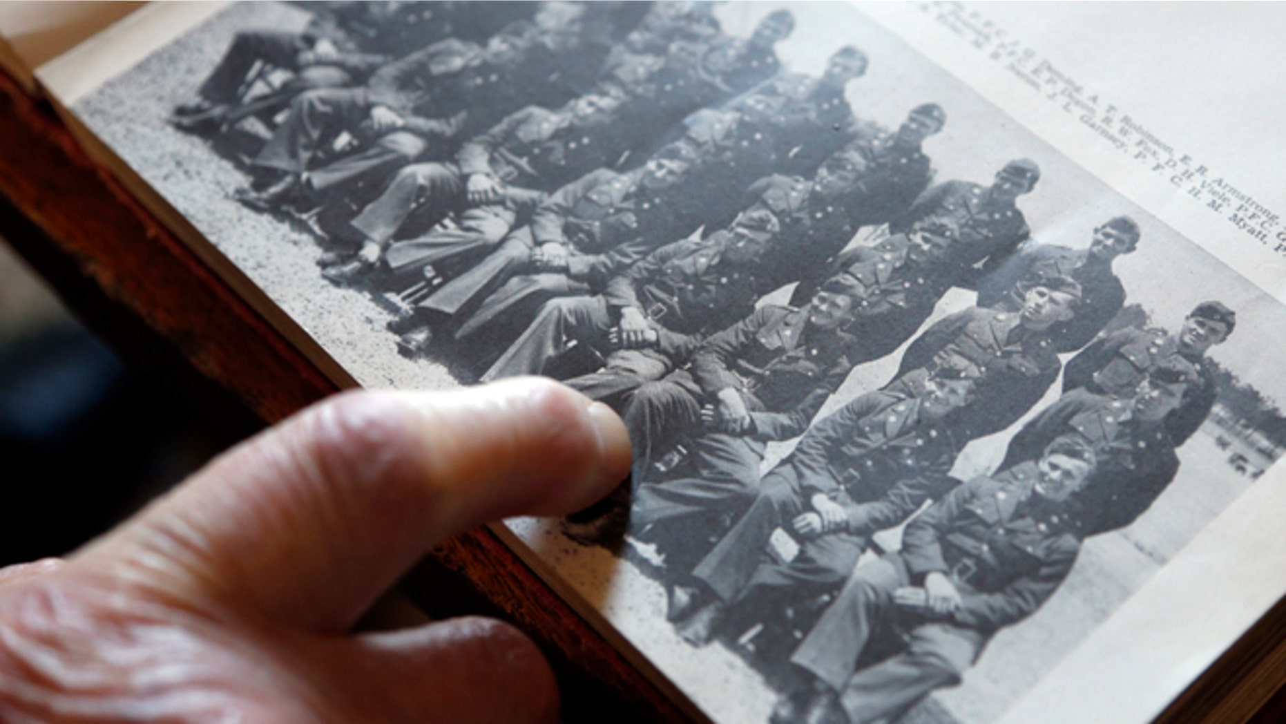 May 8, 2014: World War II veteran Arthur Robinson of Saratoga Springs, N.Y., points to himself in a 1940 photograph with his unit at the New York State Military Museum in Saratoga Springs. (AP)