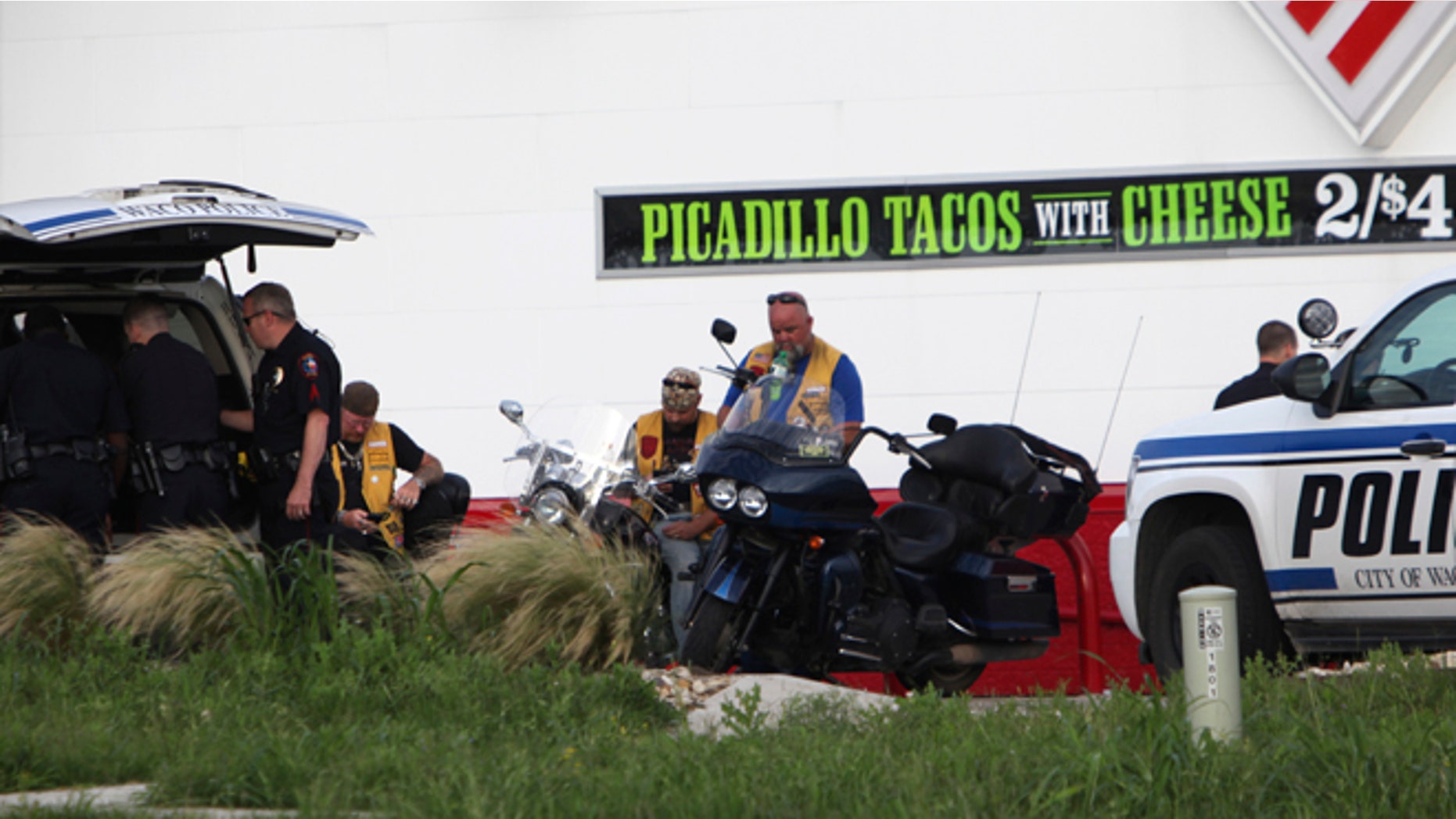 Police detain and watch members of various motorcycle clubs near a Twin Peaks restaurant in Waco, Texas, Sunday, May 17, 2015. A shootout among rival motorcycle gangs at the popular Texas restaurant left nine bikers dead and more than a dozen injured, a police spokesman said Sunday. (AP Photo/John L. Mone)