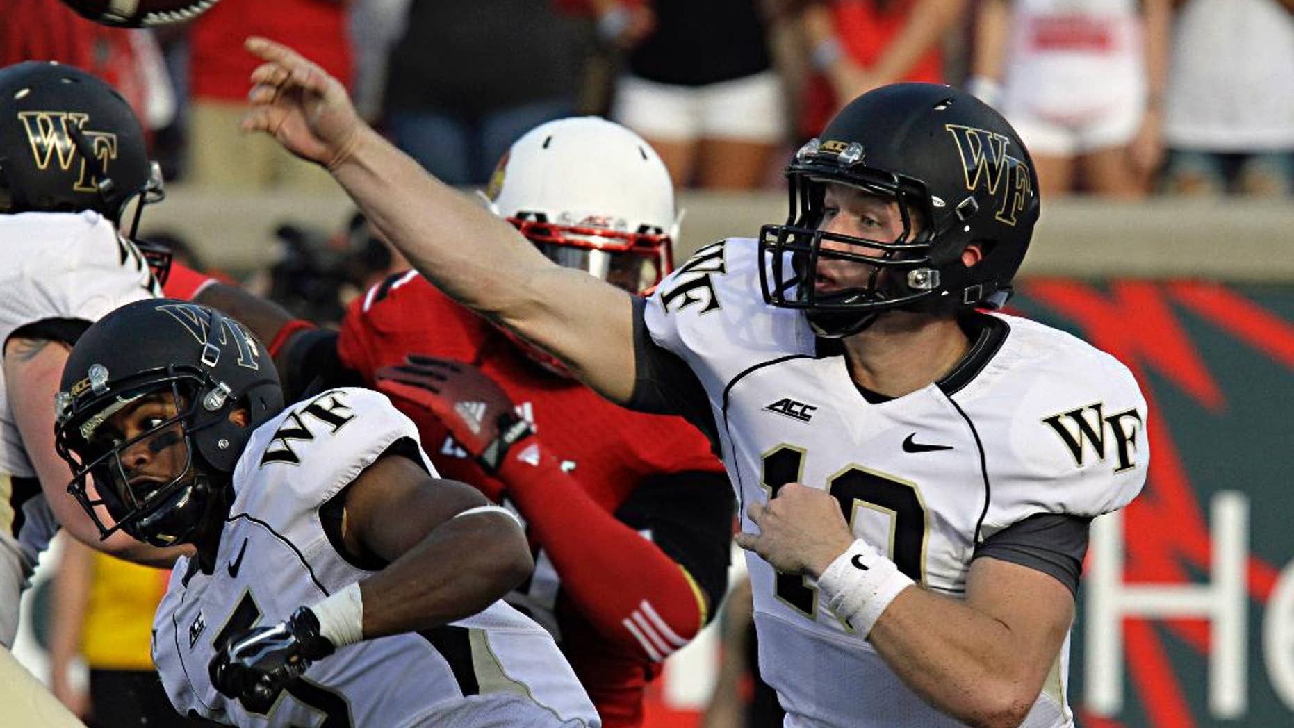 Wake Forest quarterback John Wolford launches a pass attempt against Louisville in their NCAA college football game in Louisville, Ky., Saturday, Sept. 27, 2014. Wolford completed 19 of 34 passes and threw three interceptions in the 20-10 Louisville victory. (AP Photo/Garry Jones)