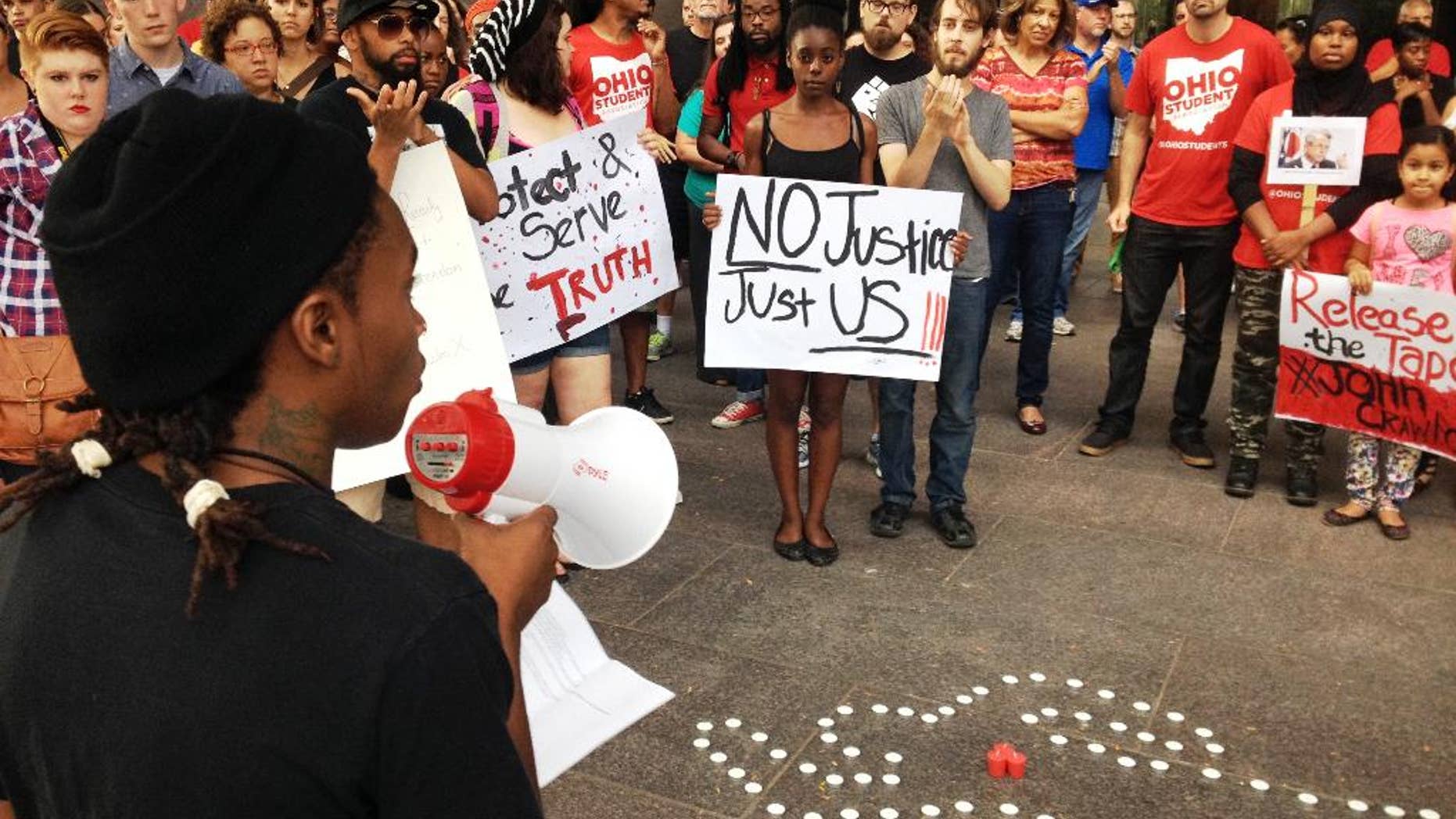 In this photo taken on Monday, Aug. 5, 2014, members of the Ohio Student Association gathered outside Ohio Attorney General Mike DeWine's office in Columbus, Ohio, to call for the release of in-store video in the fatal police shooting of a man at a Dayton-area Wal-Mart. Organizers tell the Dayton Daily News they want to see what happened on Aug. 5 when 21-year-old John Crawford III was fatally shot by police. Officers say he refused to drop an air rifle inside a Wal-Mart store in Beavercreek. (AP Photo/The Dayton Daily News, Jim Otte) LOCAL PRINT OUT; LOCAL TELEVISION OUT; WKEF-TV OUT; WRGT-TV OUT; WDTN-TV OUT