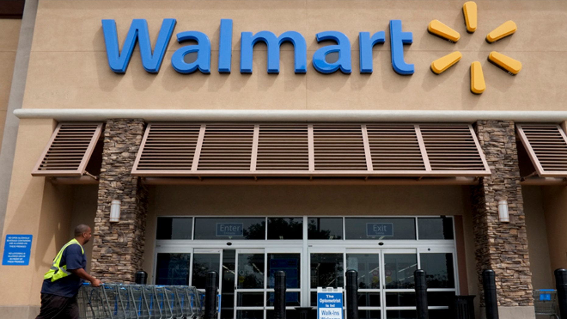 FILE - In this May 9, 2013 file photo, a worker pushes shopping carts in front of a Wal-Mart store in La Habra, Calif. Wal-Mart is turning to its marketing chief in China to shape how it relays its message to shoppers in the U.S. The worldâs largest retailer named Tony Rogers as chief marketing officer for the U.S. Friday, Dec. 18, 2015. He will report to Greg Foran, president and CEO of Wal-Martâs U.S. division starting in mid-January. (AP Photo/Jae C. Hong, File)