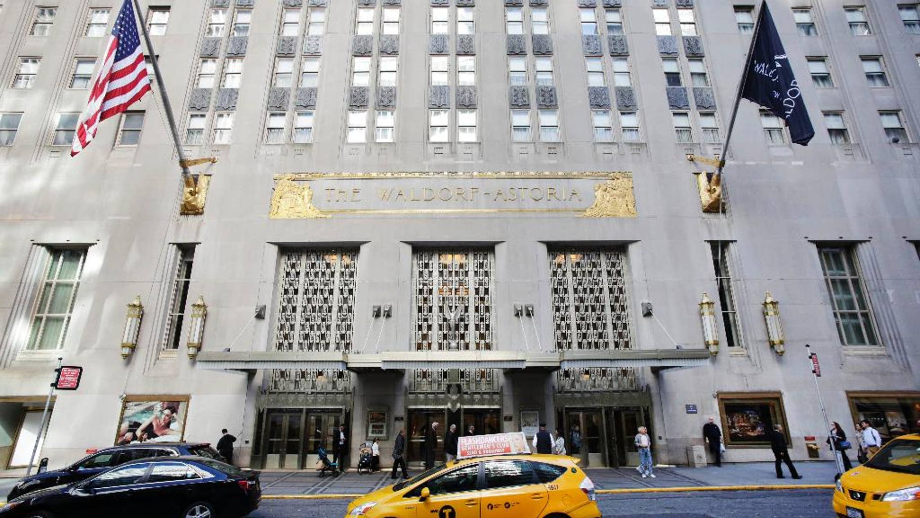 FILE - In this Oct. 6, 2014 file photo, a taxi passes in front of the fabled Waldorf Astoria hotel in New York. A police source said a wedding guest’s gun went off accidentally at New York’s Waldorf Astoria Hotel, Saturday, June 13, 2015, and a few people suffered minor injuries from debris. (AP Photo/Mark Lennihan, File)