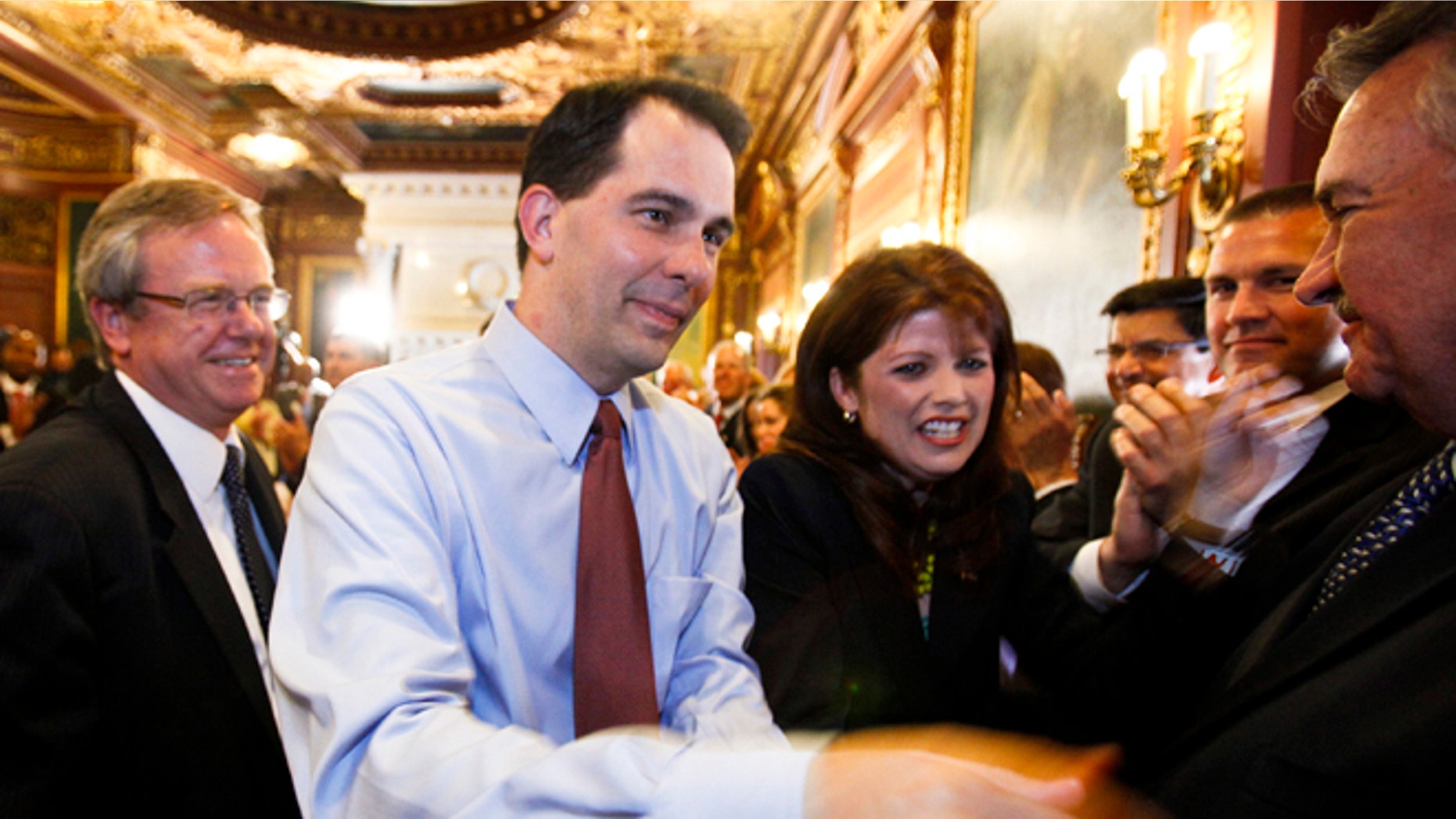 June 6, 2012: Wisconsin Gov. Scott Walker, second from left, and Lt. Gov. Rebecca Kleefisch are greeted by the governor's cabinet and staff at the Wisconsin State Capitol in Madison.