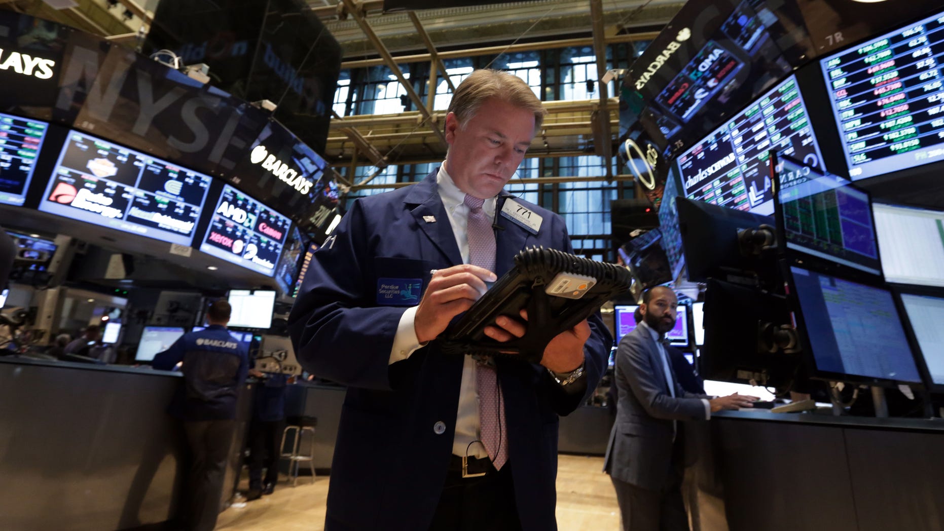 In this file photo, Trader F. Hill Creekmore works on the floor of the New York Stock Exchange.
