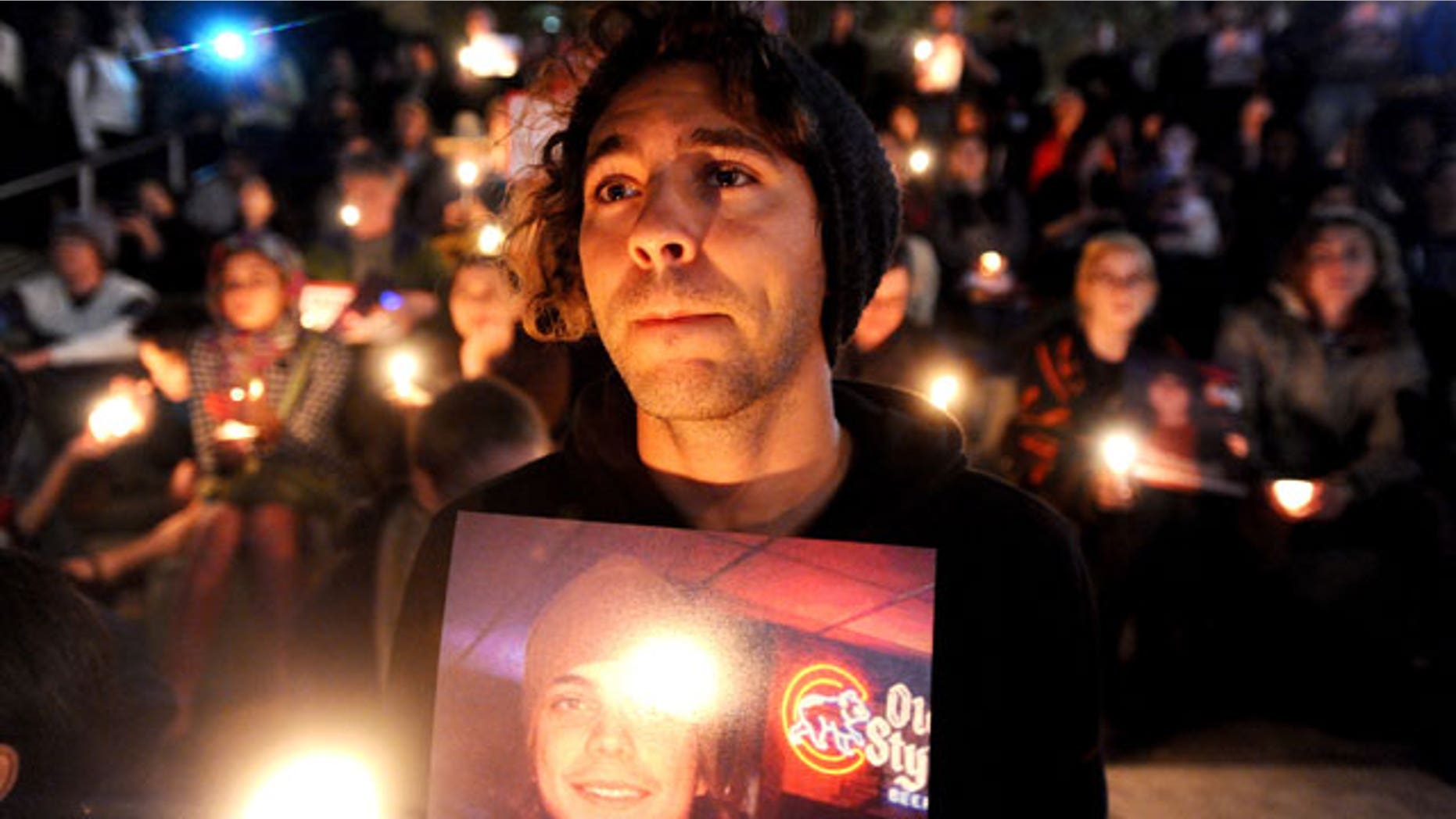 Oct. 27, 2011: Zachary Greer holds a photo of Scott Olsen during a candlelight vigil.