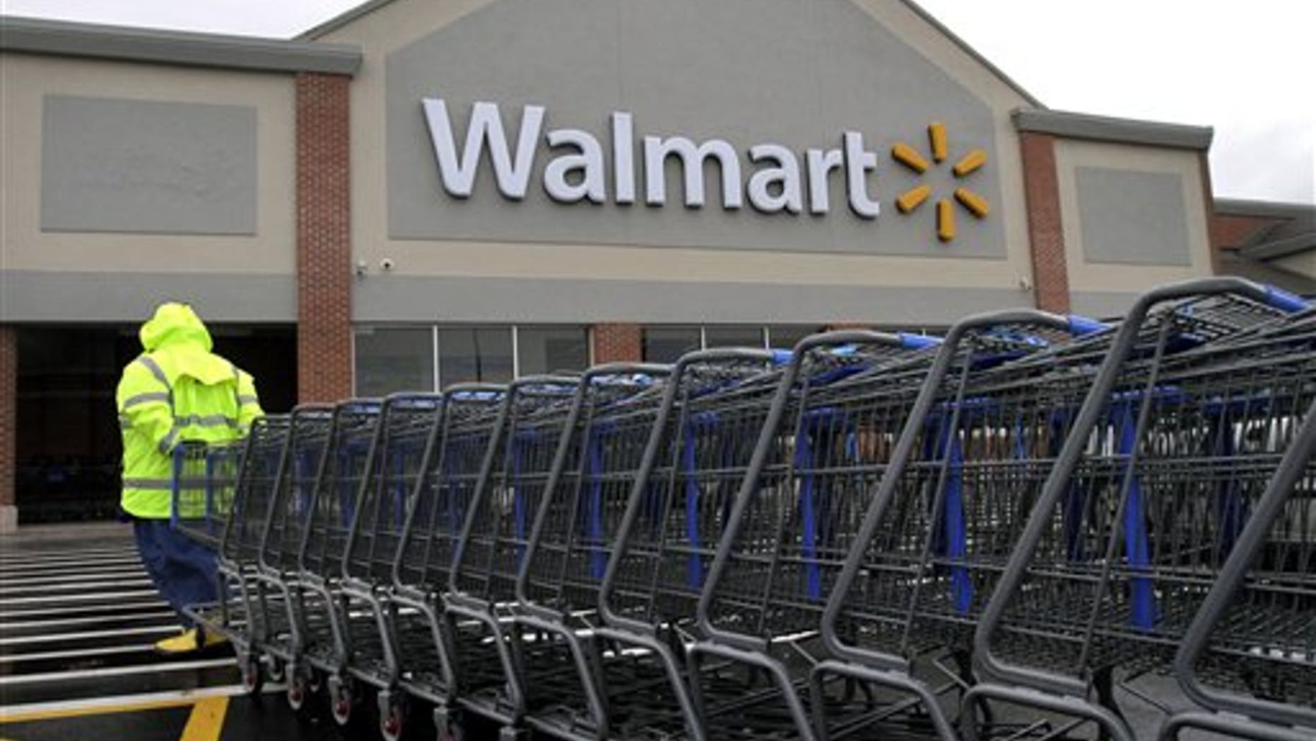 Nov. 13, 2012: A worker pulls a line of shopping carts toward a Walmart store in North Kingstown, R.I. Wal-Mart Stores Inc. reported a 9 percent increase in net income for the third quarter, but revenue for the world's largest retailer fell below Wall Street forecasts as its low-income shoppers continue to grapple with an uncertain economy.
