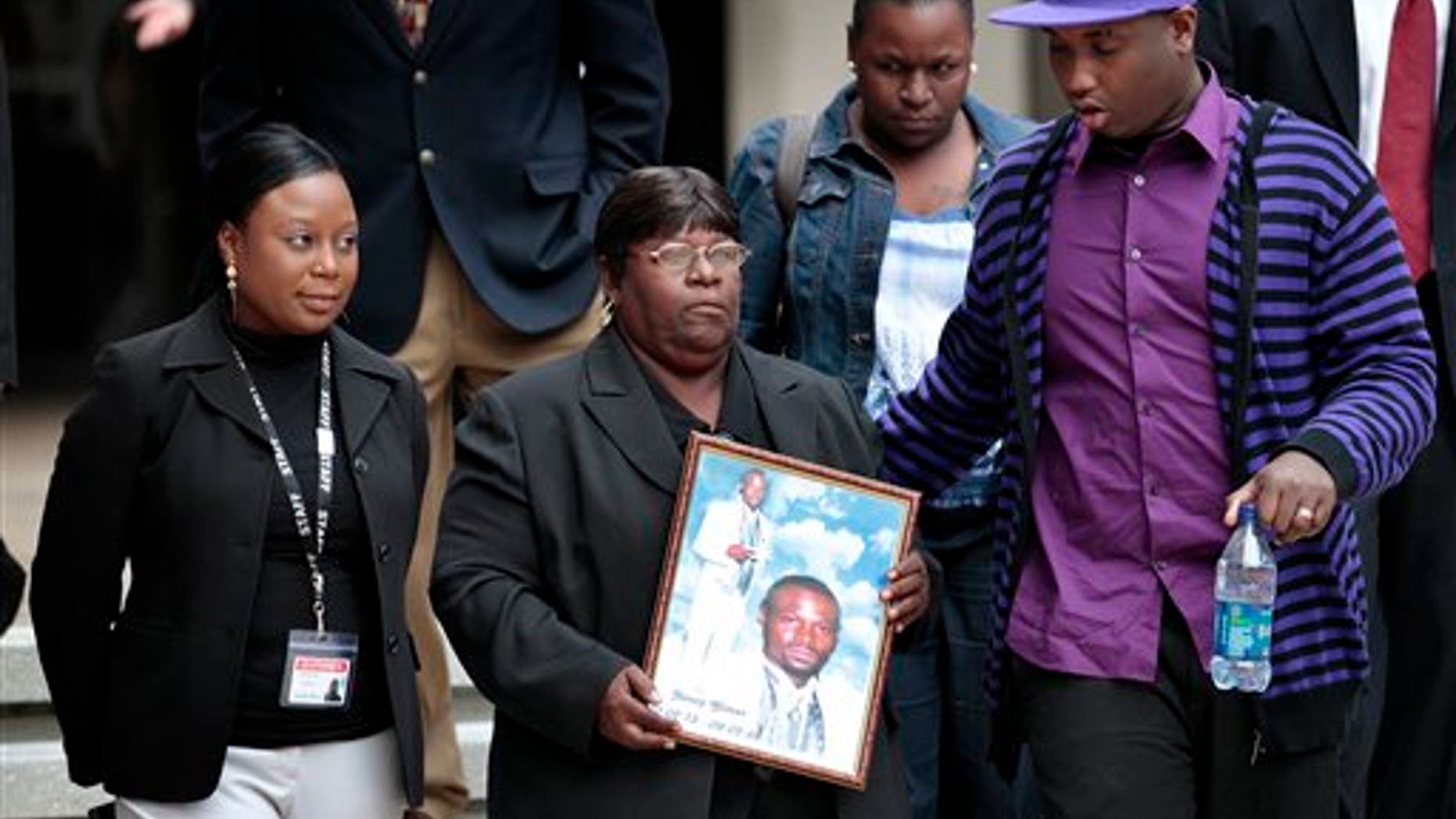 March 31: Edna Glover, mother of Henry Glover, leaving Federal Court holding his photo after the sentencing of two New Orleans police offers in his death.
