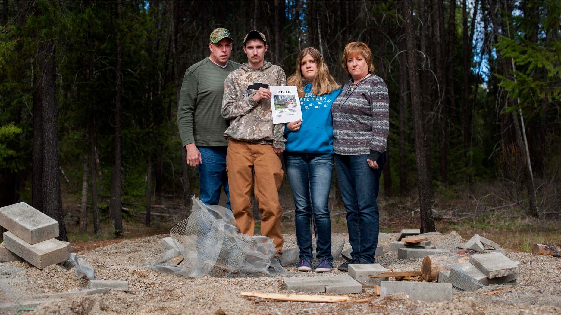 April 8, 2015: Moose Hempel, left, stands with his children, Tyler and Kayla and wife Chris, at the site where their cabin used to stand.