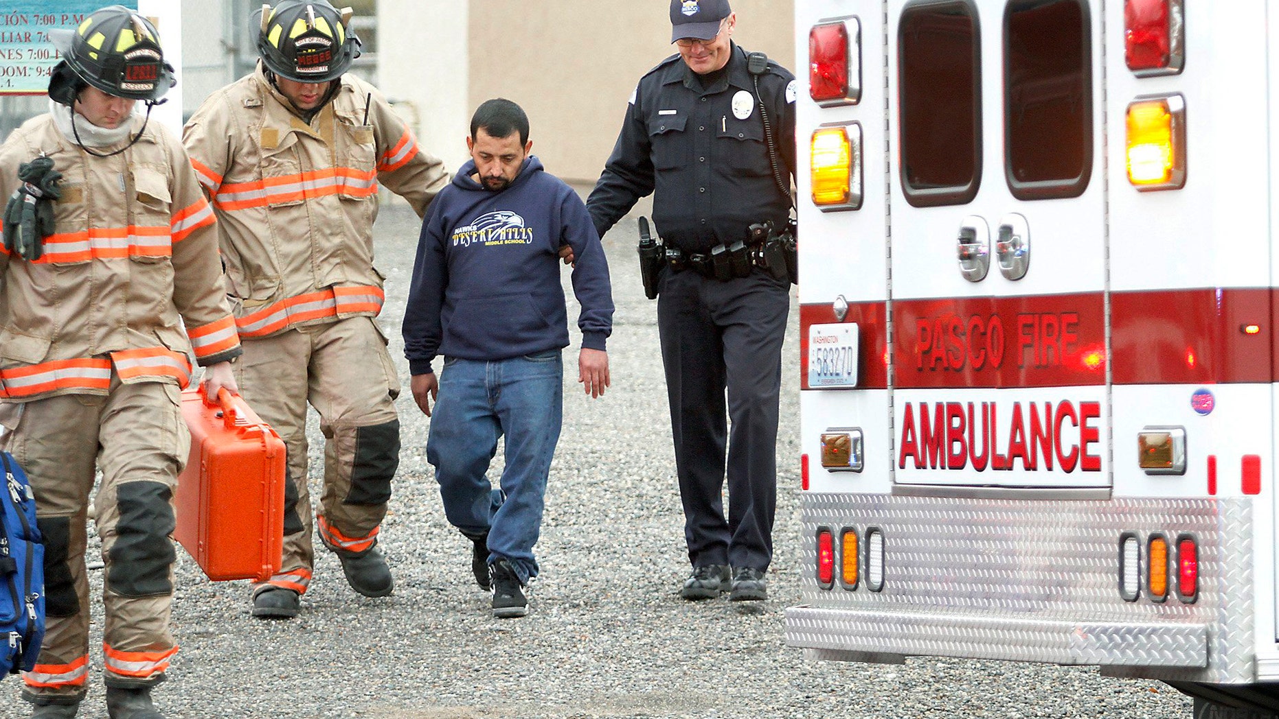 In this Jan. 22, 2015 photo, Pasco firefighters and Dean Perry, right, a Pasco police officer, help Antonio Zambrano-Montes, second from right, to an ambulance following a house fire in Pasco, Wash. On Feb. 10, 2015, Zambrano-Montes was fatally shot by police after he ran from them after throwing rocks at cars at an intersection in Pasco. Reports about Zambrano-Montes' interactions with police, obtained by The Associated Press through a public records request, provide new details about his behavior and the extent to which the Pasco Police Dept. was aware of his issues. (Bob Brawdy/Tri-City Herald via AP)