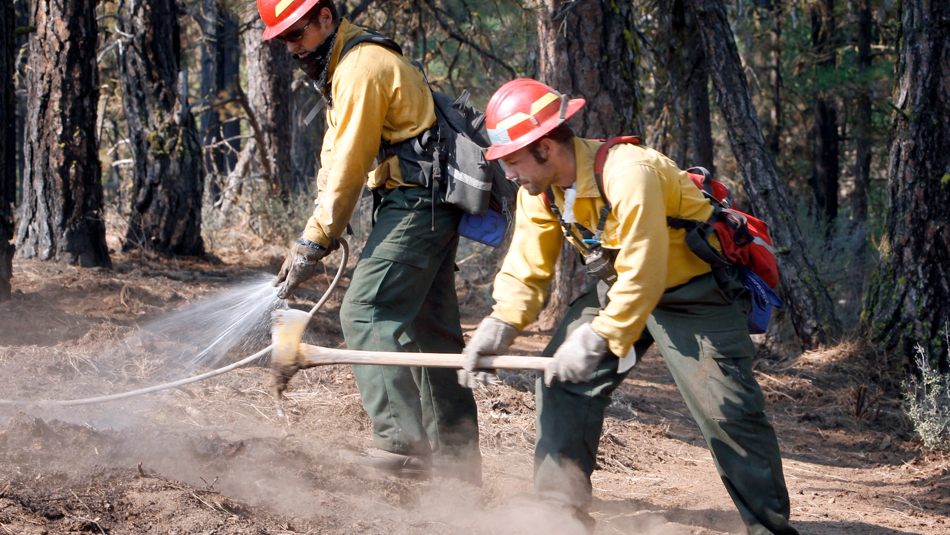 September 10: Alex George, left, and Kevin Weed of Glacier Peak Wildfire, Inc., extinguish hot spots along a fire line near Box Canyon Road on the eastern boundary of the Monastery Complex Fire in Yakima, Washington.