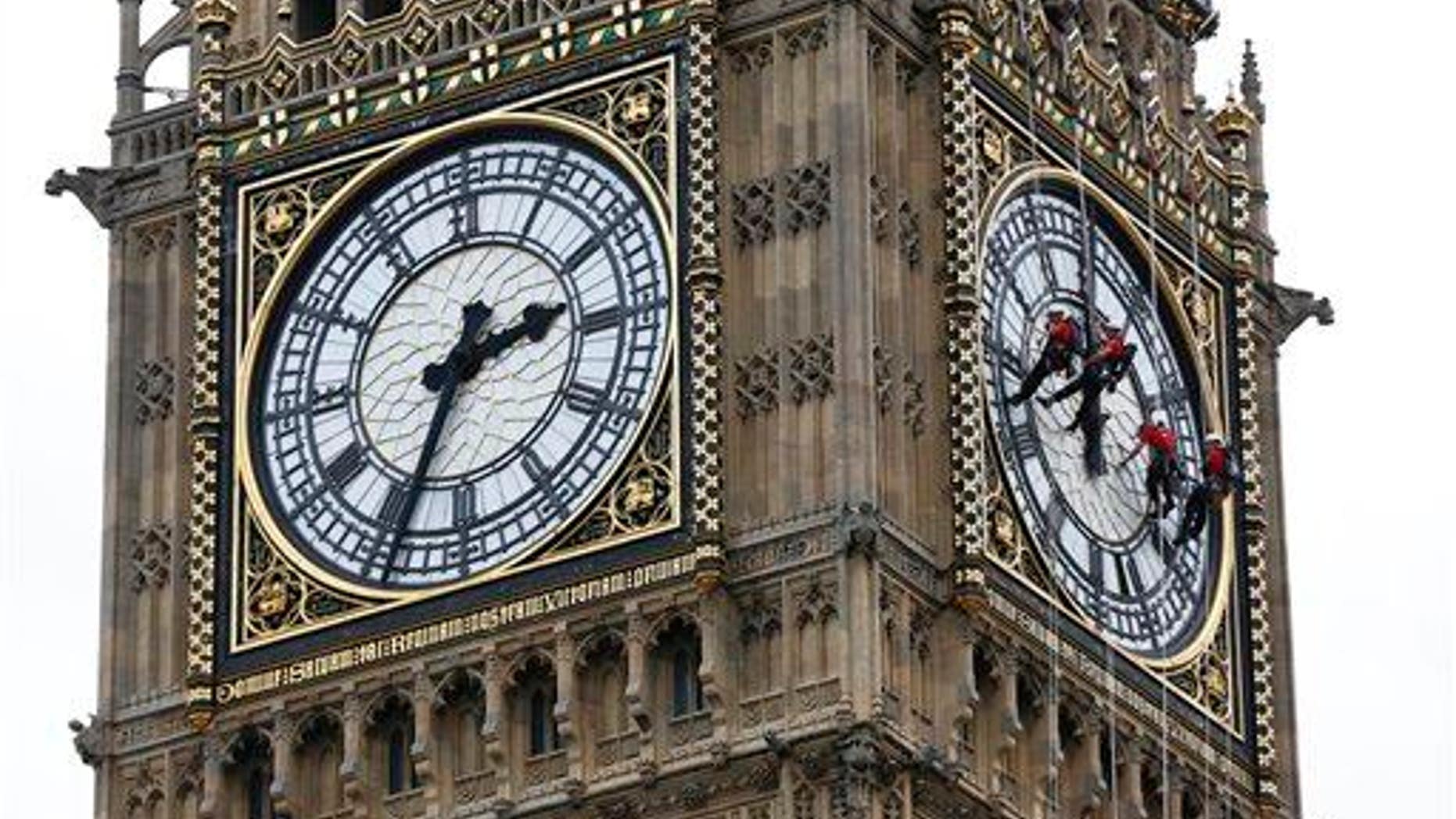 Workers clean the face of Big Ben in London.