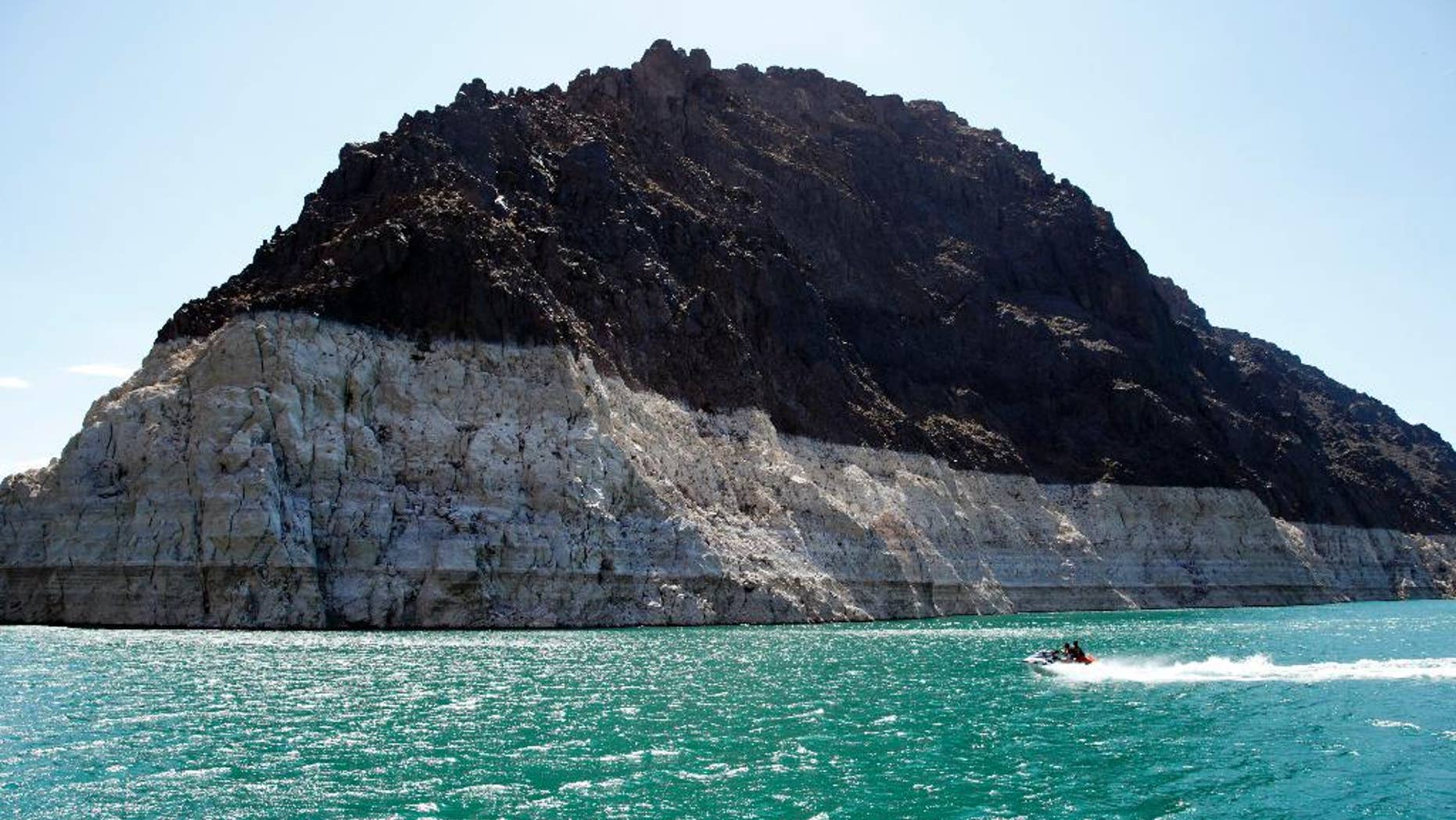 FILE - In this July 17, 2014 file photo, recreational boaters ride by a bathtub ring that delineates the high water mark at Lake Mead in the Lake Mead National Recreation Area in Nevada. Water managers in Las Vegas and the Los Angeles area have reached a deal to draw enough water to serve some 300,000 homes from the Lake Mead reservoir on the Colorado River and sell it to California. (AP Photo/John Locher,File)