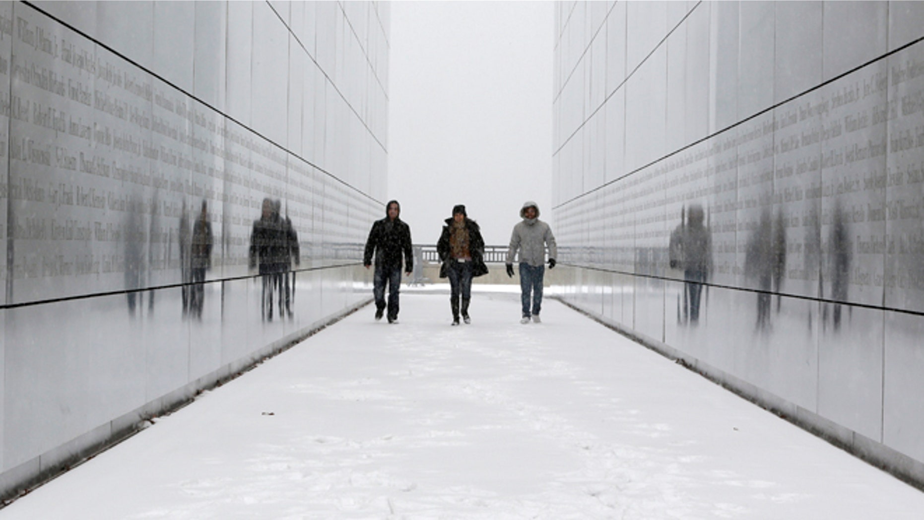 FILE - In this Tuesday, Jan. 21, 2014 file photo, tourists walk through the snow-covered Empty Sky Memorial at Liberty State Park in Jersey City, N.J. Researchers who analyzed local climate trends and hospital records on millions of Americans say there may be a link between weather and the risk for stroke. Cold weather, high humidity and big daily temperature swings brought more stroke hospitalizations. The study by researchers from Yale, Harvard and Duke universities was discussed Wednesday, Feb. 12, 2014 at a stroke conference in San Diego. (AP Photo/Julio Cortez)