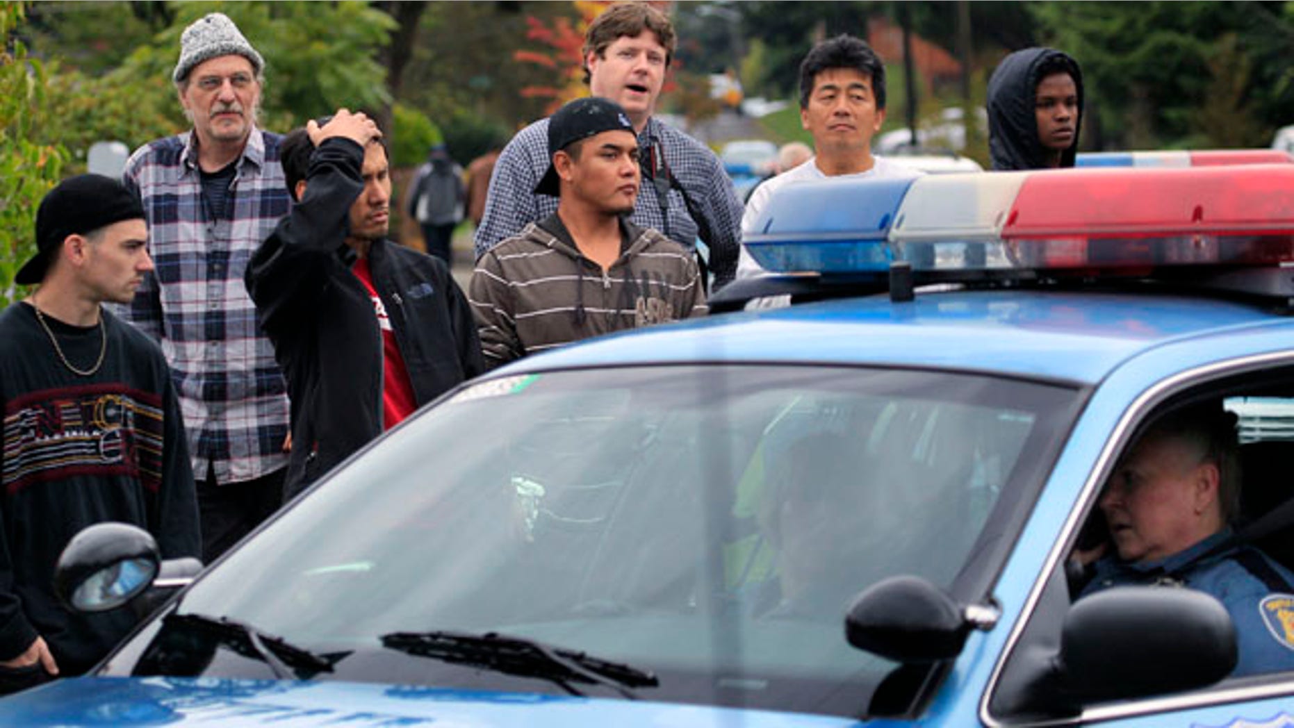 Neighbors look on at the scene of a shooting that left four people dead and another wounded Thursday, Sept. 23, 2010, in Seattle. The woman suspected of firing the shots at the southwest Seattle home apparently is among the dead. (AP Photo/Elaine Thompson)