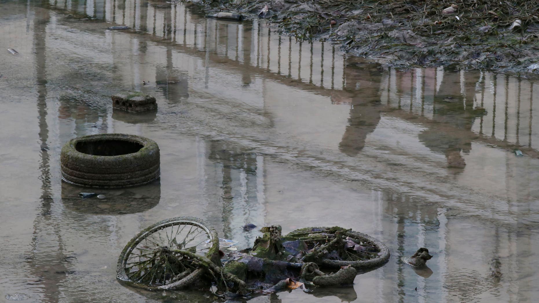 A bicycle and a tire are seen on the ground of the Canal Saint-Martin as the canal is drained for maintenance in Paris on Wednesday.