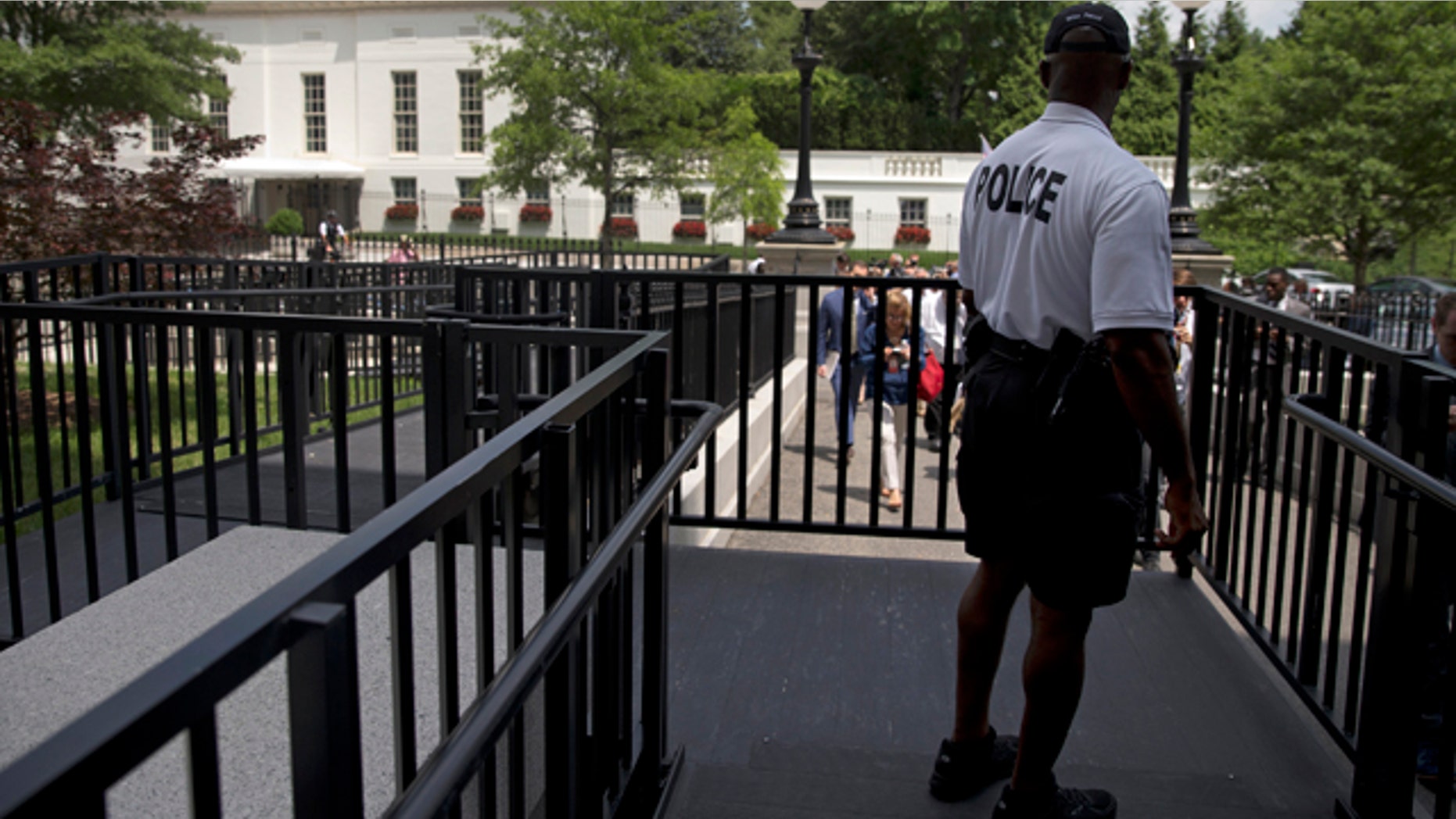 June 9, 2015: A member of the Secret Service Police looks toward the West Wing of the White House in Washington during an evacuation of the media area of the White House because of a bomb threat. (AP Photo/Carolyn Kaster)