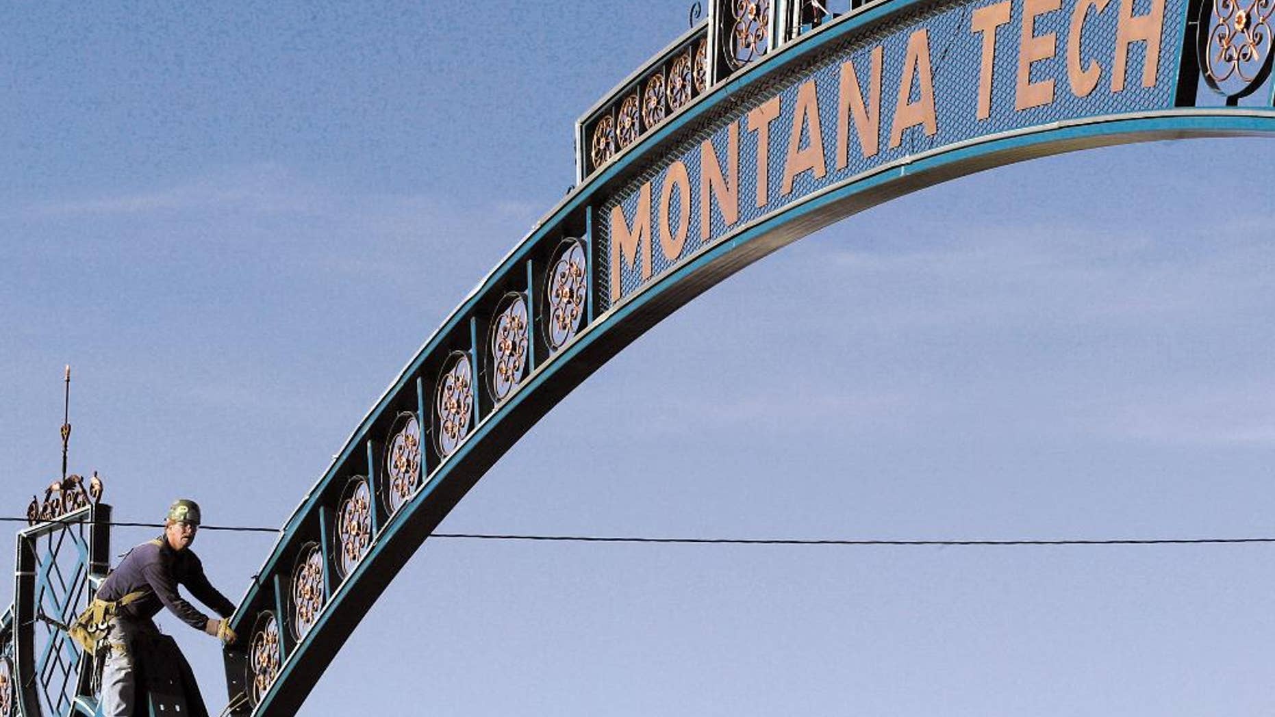 FILE - In this Aug. 26, 2003 file photo, a worker guides the new Montana Tech archway into place above Park Street in Butte, Mont. A group of Saudi students caught up in a cheating scandal at the college were secretly offered flights home by the kingdom’s diplomats to avoid the possibility of arrest, according to a cache of embassy memos recently published by WikiLeaks and a senior official at the school. (Lisa Hornstein/The Montana Standard via AP, File)