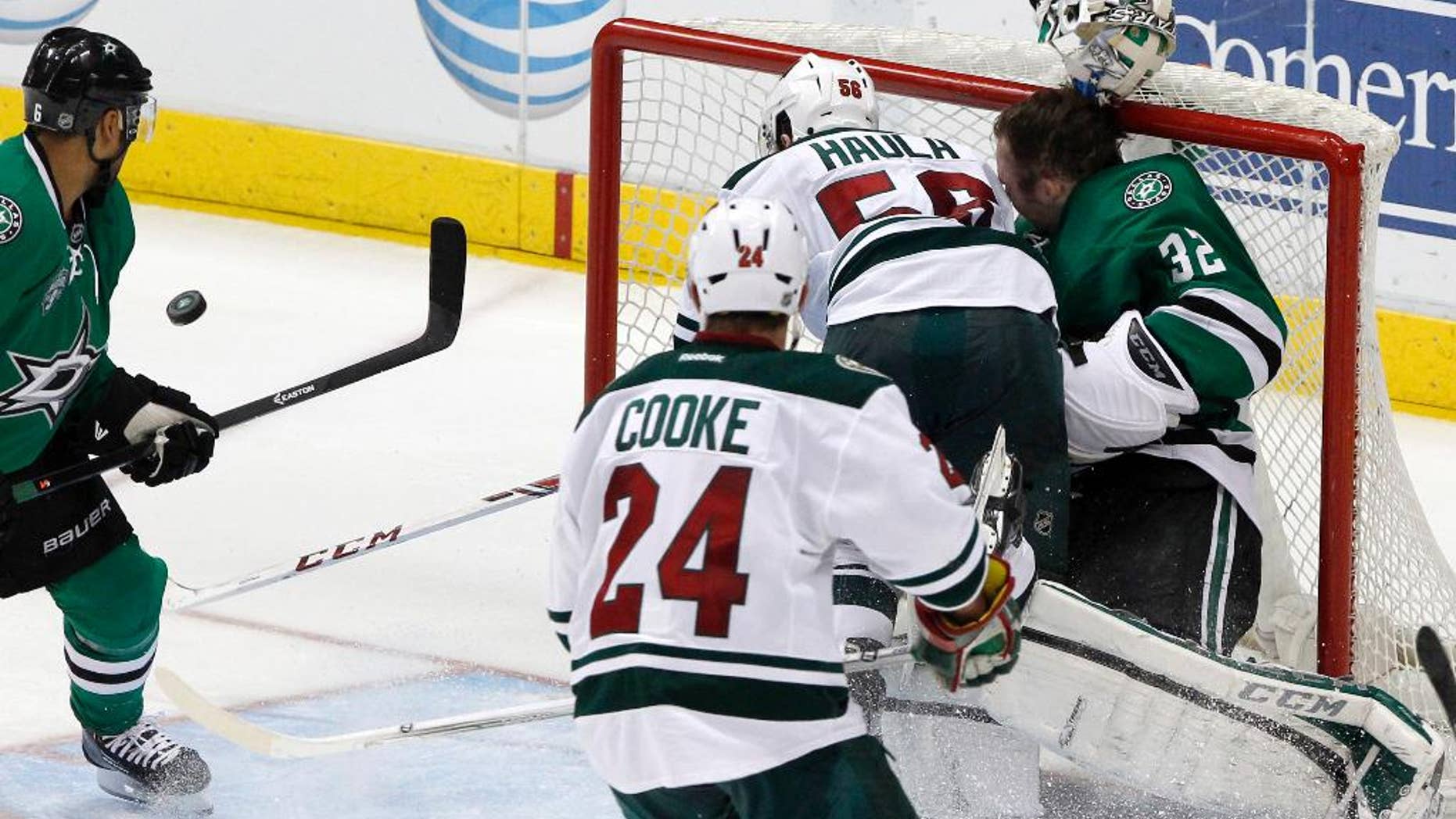 Minnesota Wild left wing Erik Haula (56) collides with Dallas Stars goalie Kari Lehtonen (32), who loses his helmet during the third period an NHL hockey game in Dallas Saturday, March 8, 2014. The Stars won 4-3. (AP Photo/Richard W. Rodriguez)