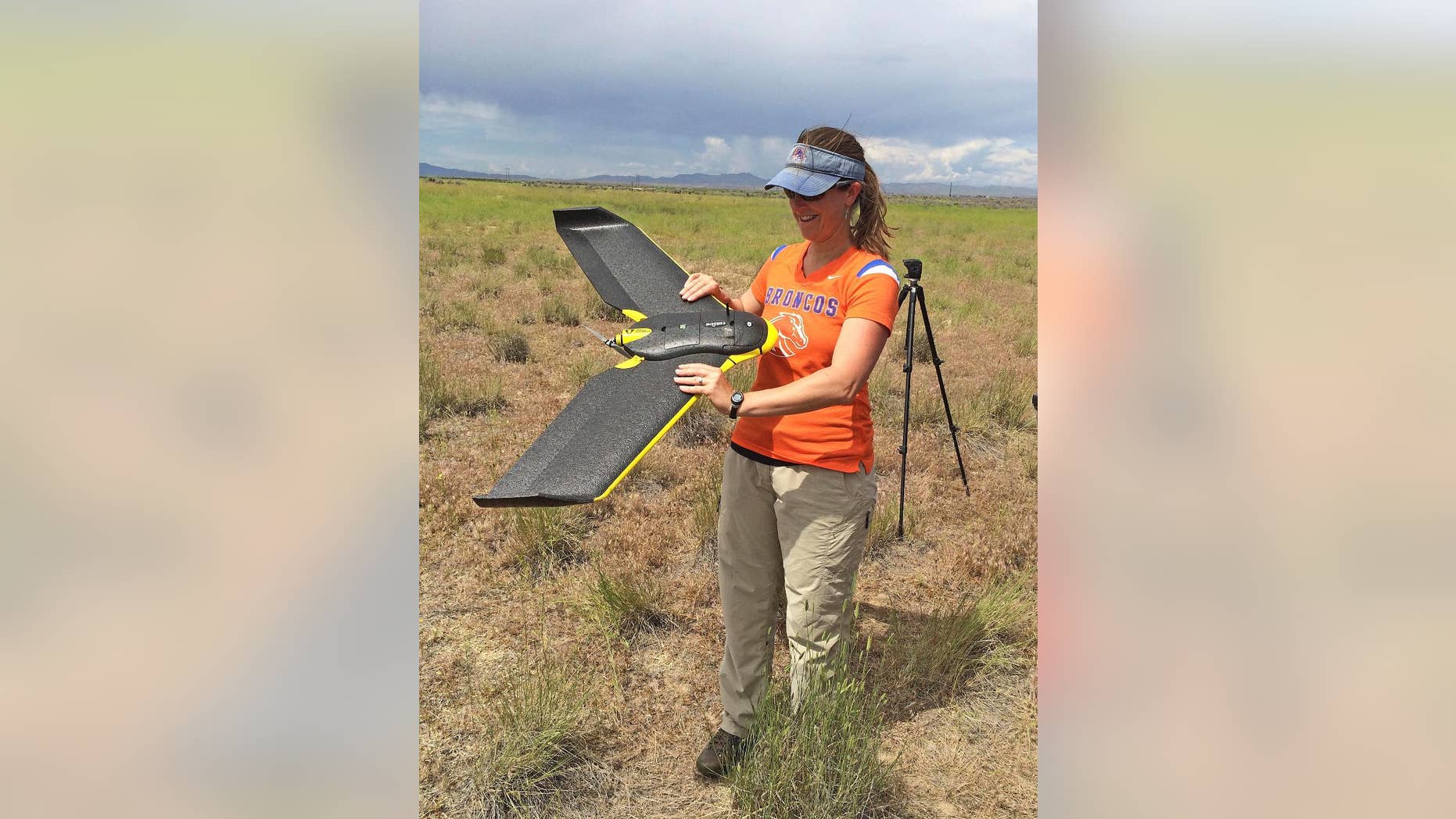 In this photo provided by Jennifer Forbey and taken June 10, 2015, Boise State University Professor Jennifer Forbey examines a drone prior to launch in an area west of Boise, Idaho. Scientists are testing camera-equipped drones in western Idaho to find out if they can identify subspecies of sagebrush as part of a wildfire strategy to help sage grouse and other wildlife across the West. (Chelsea Merriman/Courtesy of Jennifer Forbey via AP)