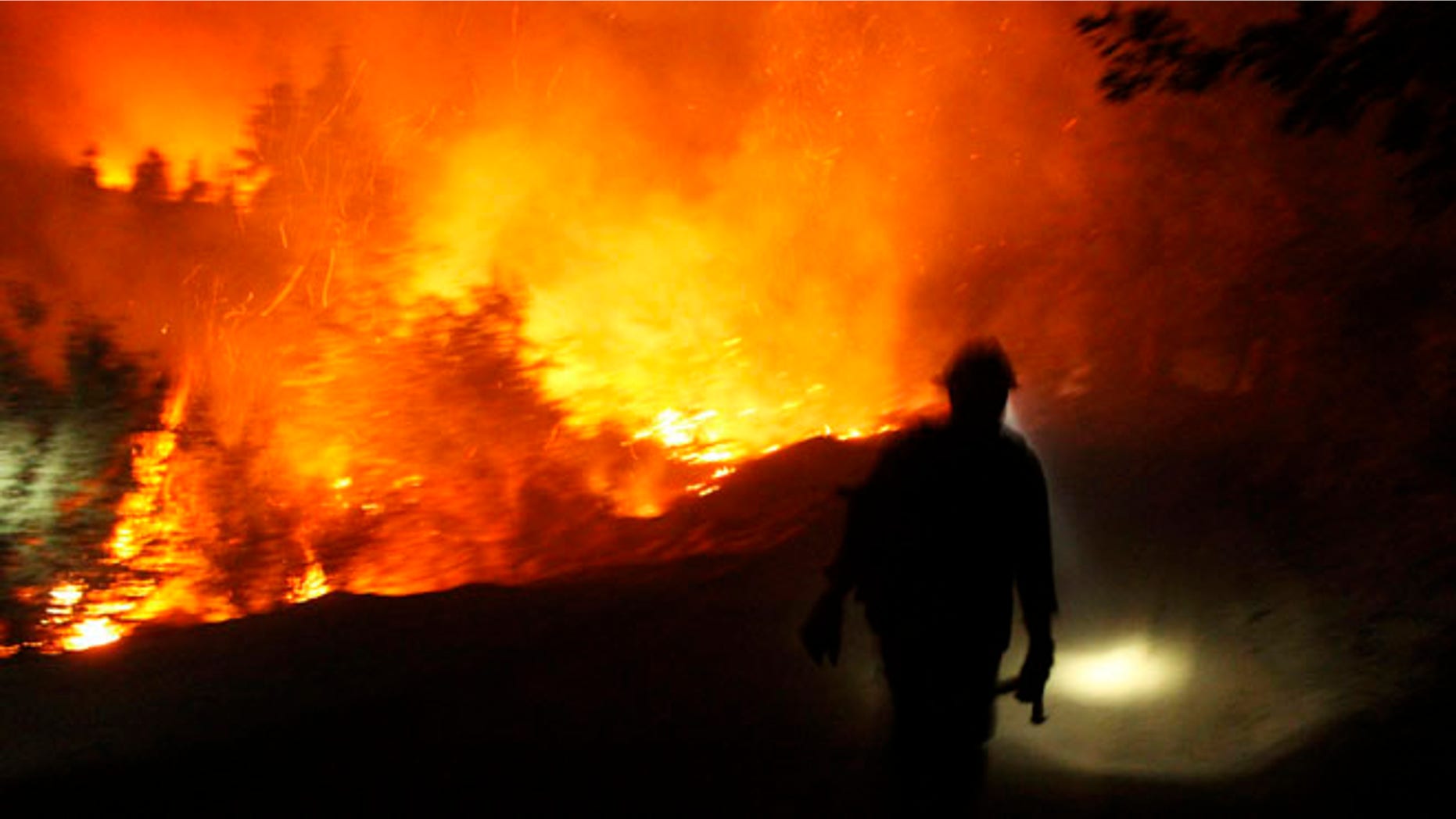 Aug 30, 2103: A firefighter uses a headlamp at the Rim Fire at night in this undated United States Forest Service handout photo near Yosemite National Park, California.