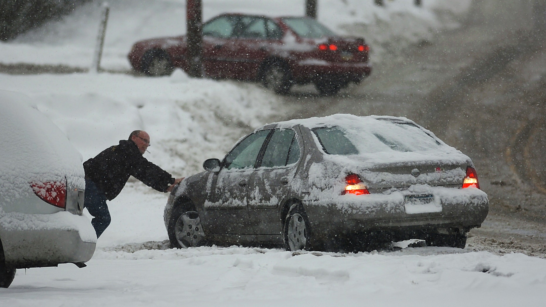 A resident helps out a motorist push his car out of the snow on an icy West Lackawanna Avenue in Blakely, Pa. on Saturday, Dec. 29, 2012. Snow from a mild but widespread winter storm began falling Saturday over most of the Northeast and the upper Ohio River Valley, the second in less than a week for the regions. (AP Photo/Scranton Times & Tribune, Butch Comegys) WILKES BARRE TIMES-LEADER OUT; MANDATORY CREDIT