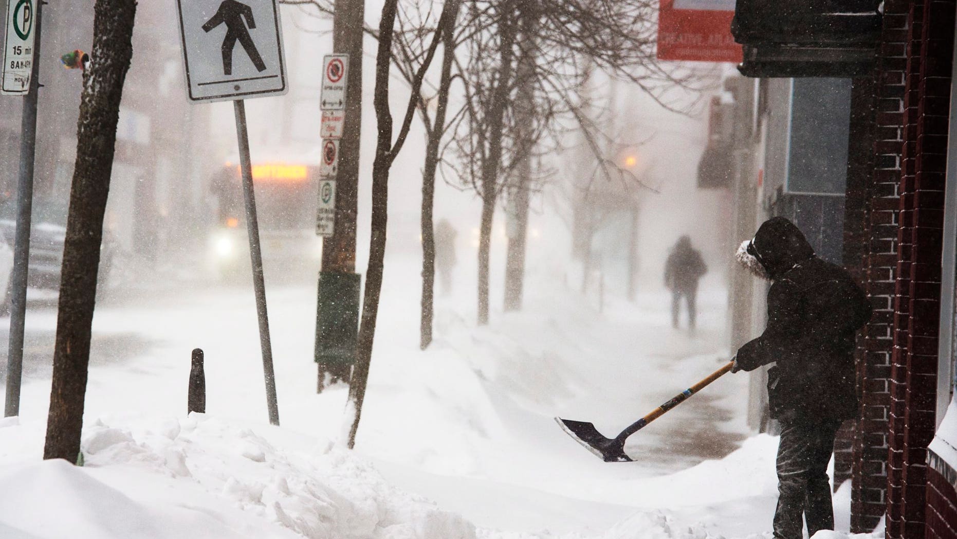 A man clears a sidewalk in blizzard conditions in Halifax, Nova Scotia, on Jan. 3, 2014.