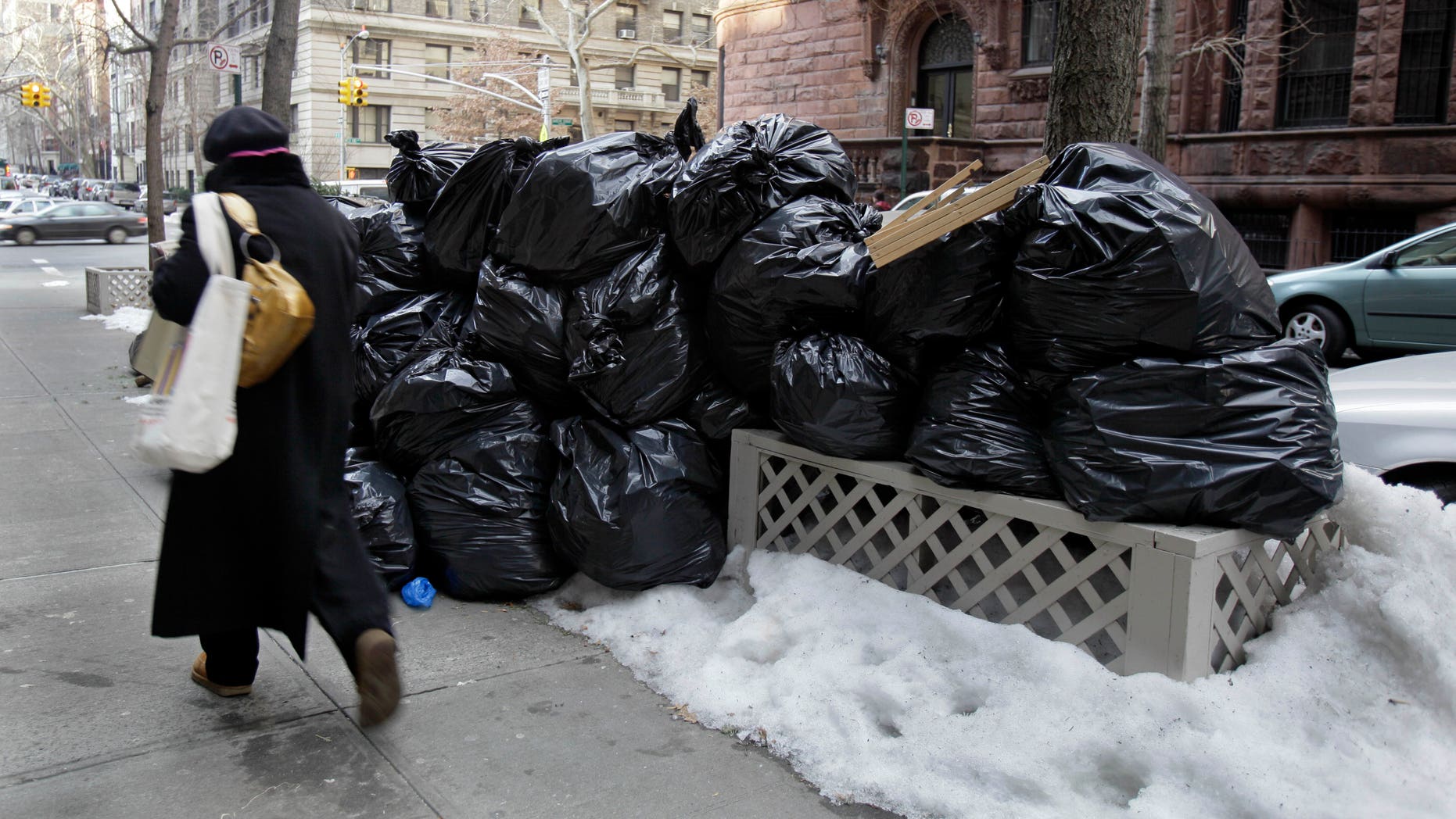 Jan. 6: A woman walks by bags of uncollected trash on New York's Upper West Side. (AP)