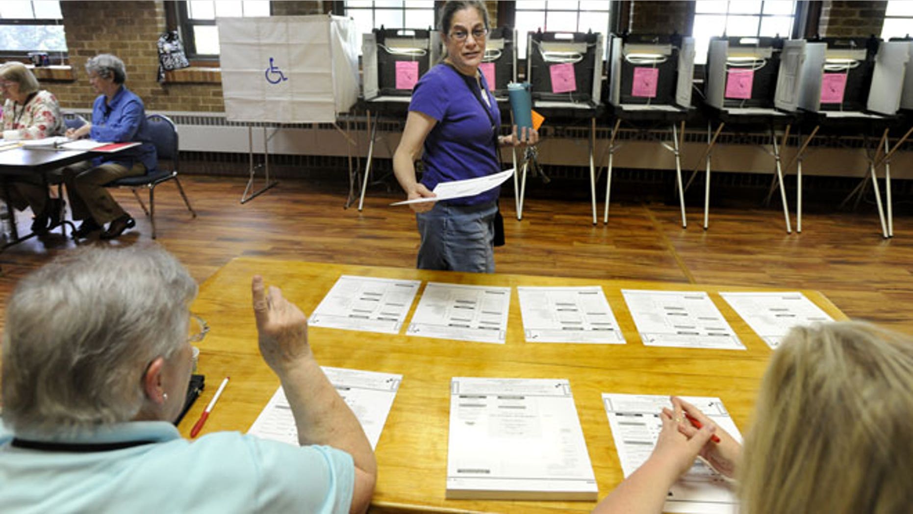 May 8, 2012: Ruth Hoover talks with poll volunteer workers Fay Tichy, left, and Jacki Helgerson, right, after receiving her ballot from them prior to voting in the Wisconsin recall primary election in the Union Grove Municipal building in Union Grove, Wis.